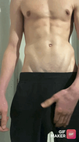 Muscular white man with abs in black shorts posing and masturbating in a selfie.