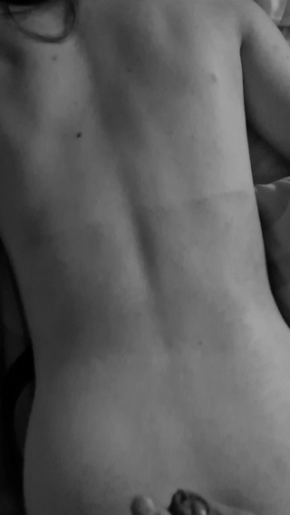 Huge dick cumshot on a slim woman's back in black and white.