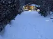 Cozy wooden cabin in the North Carolina mountains with a snow-covered path at dusk