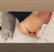 Curvy white femboy lying on a white bed, face down ass up, showing their cock and ass.