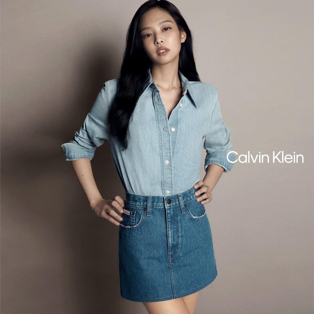 Jennie for Calvin Klein wearing a denim dress, white tank top, and denim jeans in a studio