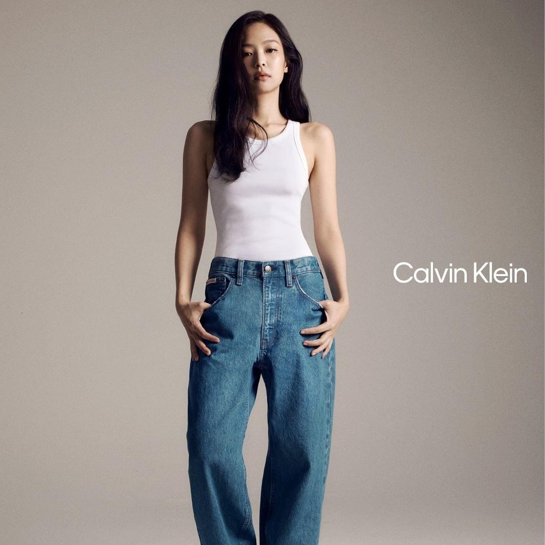 Jennie for Calvin Klein wearing a denim dress, white tank top, and denim jeans in a studio
