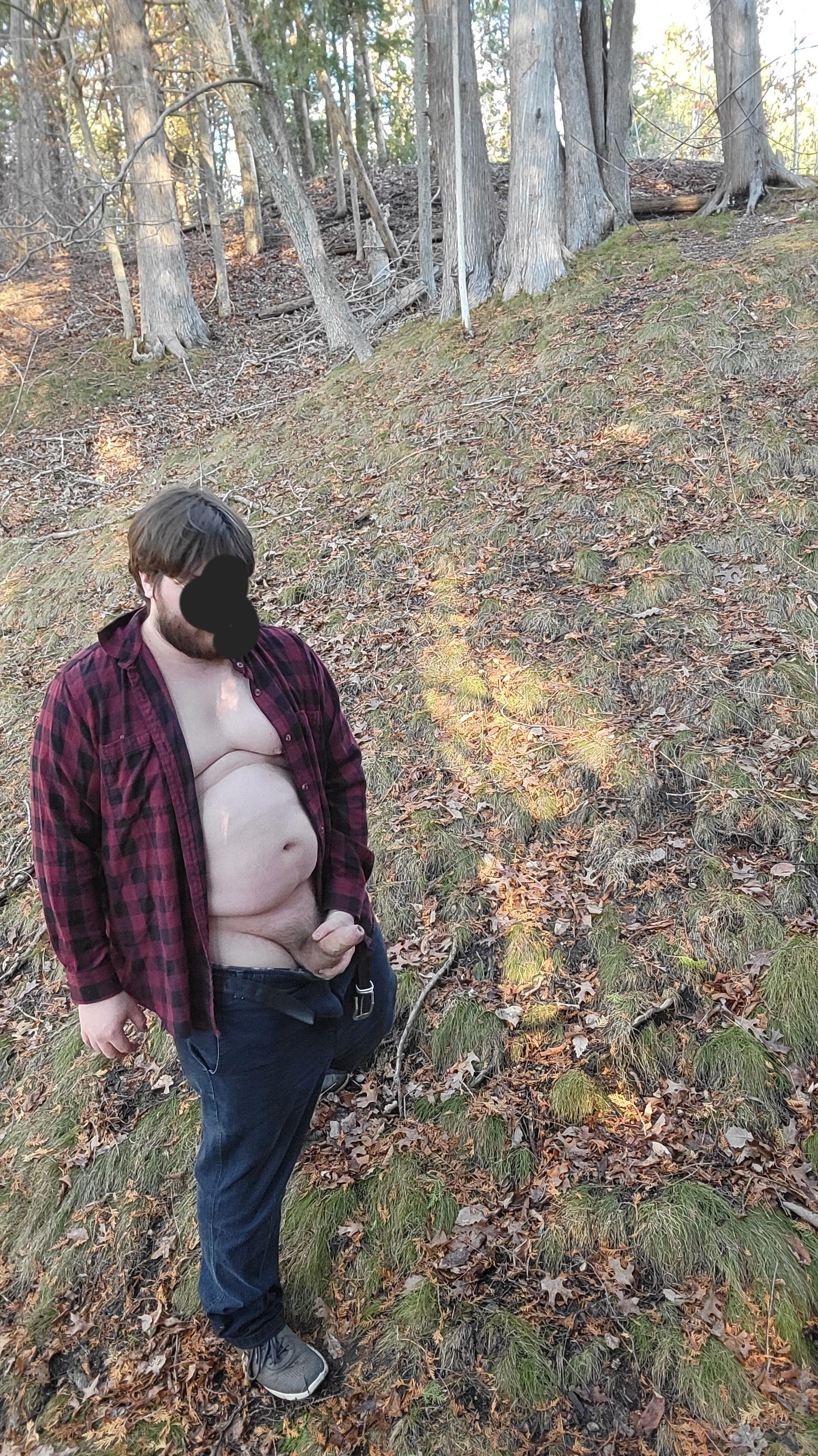 Chubby white man with a dad bod in a red plaid shirt and blue jeans exposing his uncut cock in the woods