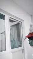 An athletic Indian man in a green parka and then in swimwear jumping into deep snow in a mountain village