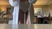 Alexandra Daddario in a white robe, bra, and underwear recording a selfie video