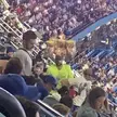 Snack vendor at baseball game carrying snacks on his head.