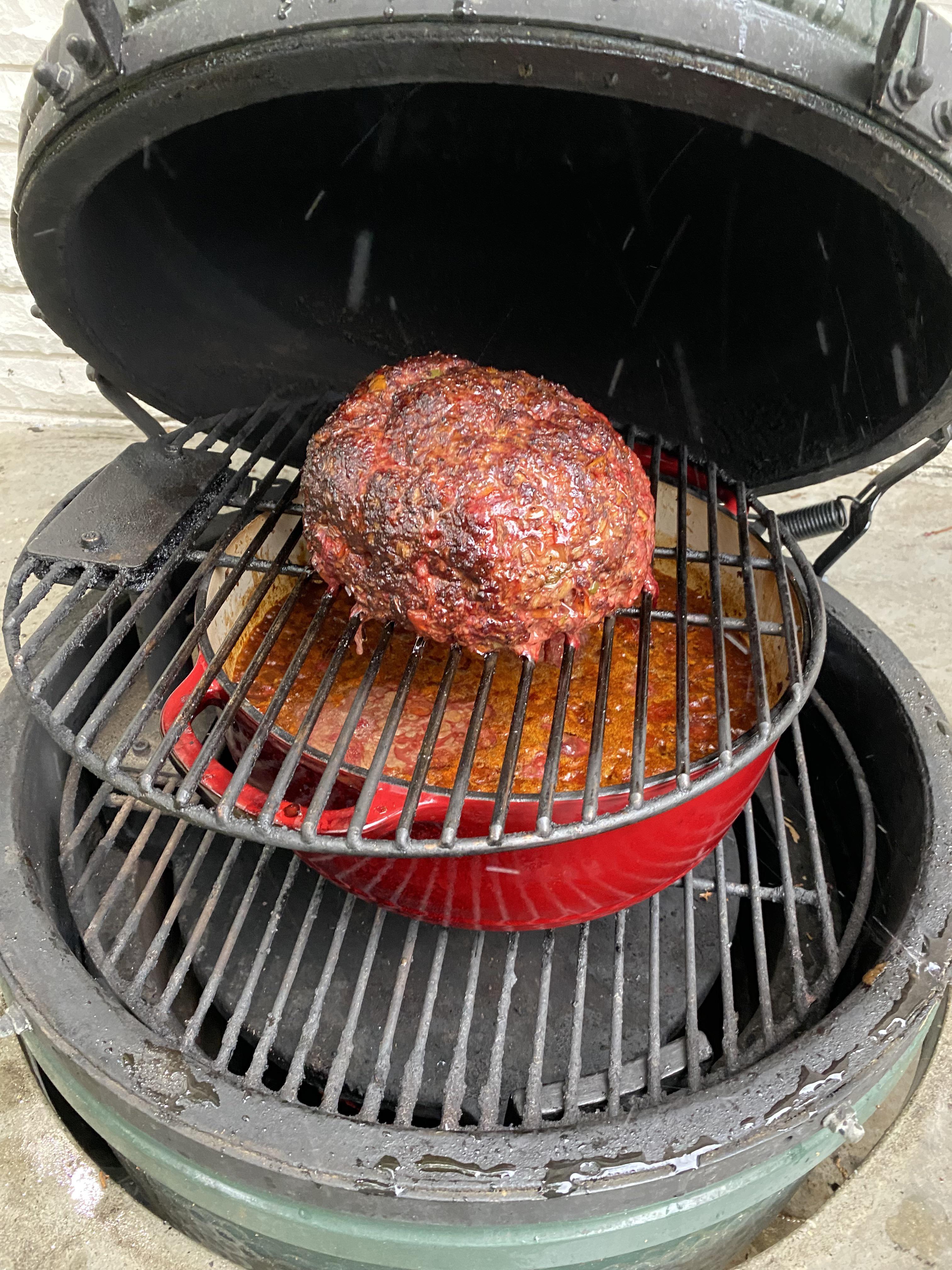 Over-the-top chili with bowls of stew, tortilla chips, and meatballs on a grill