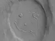 A Smile a Day.... - This picture of a crater resembling a "happy face" was taken by the Mars Reconnaissance Orbiter's Context Camera. The unnamed crater is almost 2 miles (about 3 kilometers) across That's a BIG smile!