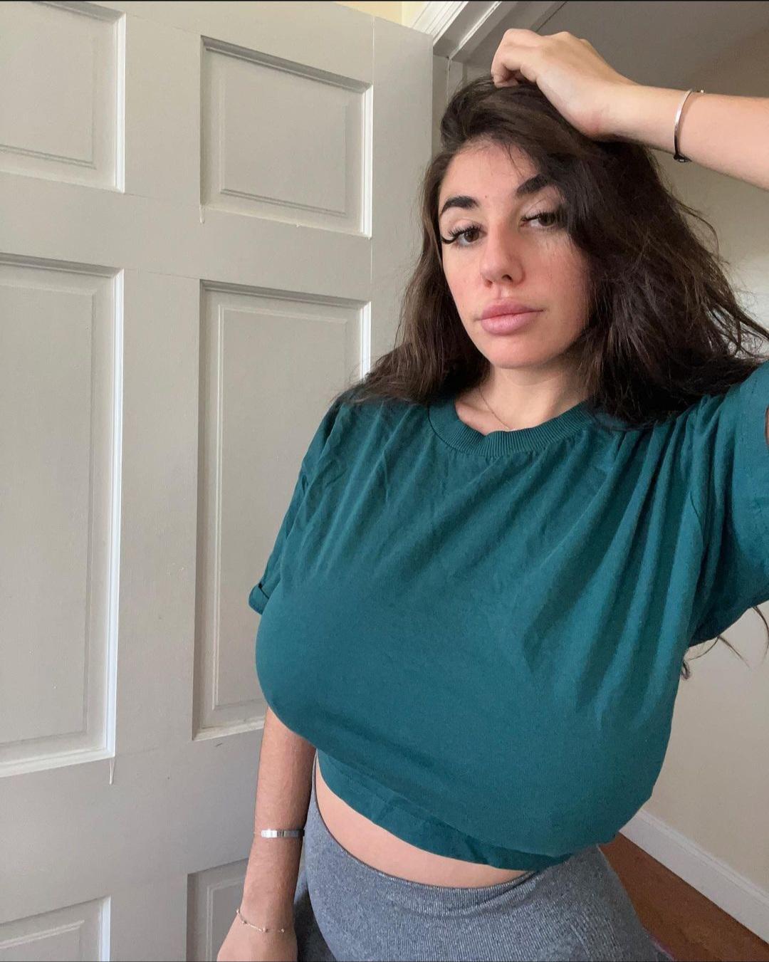 Busty white woman with long brown hair in tight ribbed tops and crop tops showcasing cleavage