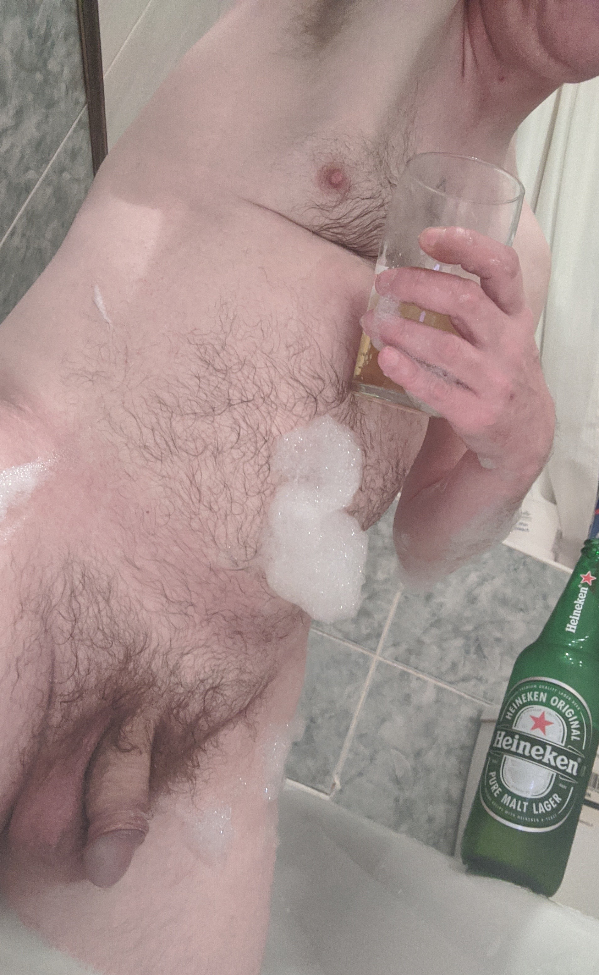 Imported Heineken out the bottle and into the glass as I get into the tub and shower hotter water on my head