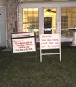 Update on the angry neighbor that puts out signs berating the guy next door. New signs are out and this time he is threatening a lawsuit… and called the guy “numbnuts”.