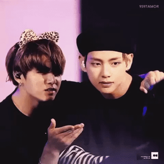 Taekook in costumes on stage; one wearing a leopard print bow and the other a black beret.