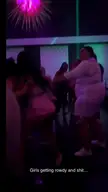 Baddies in a nightclub brawl, including a woman in a pink dress and another in a black outfit, fighting on the floor.
