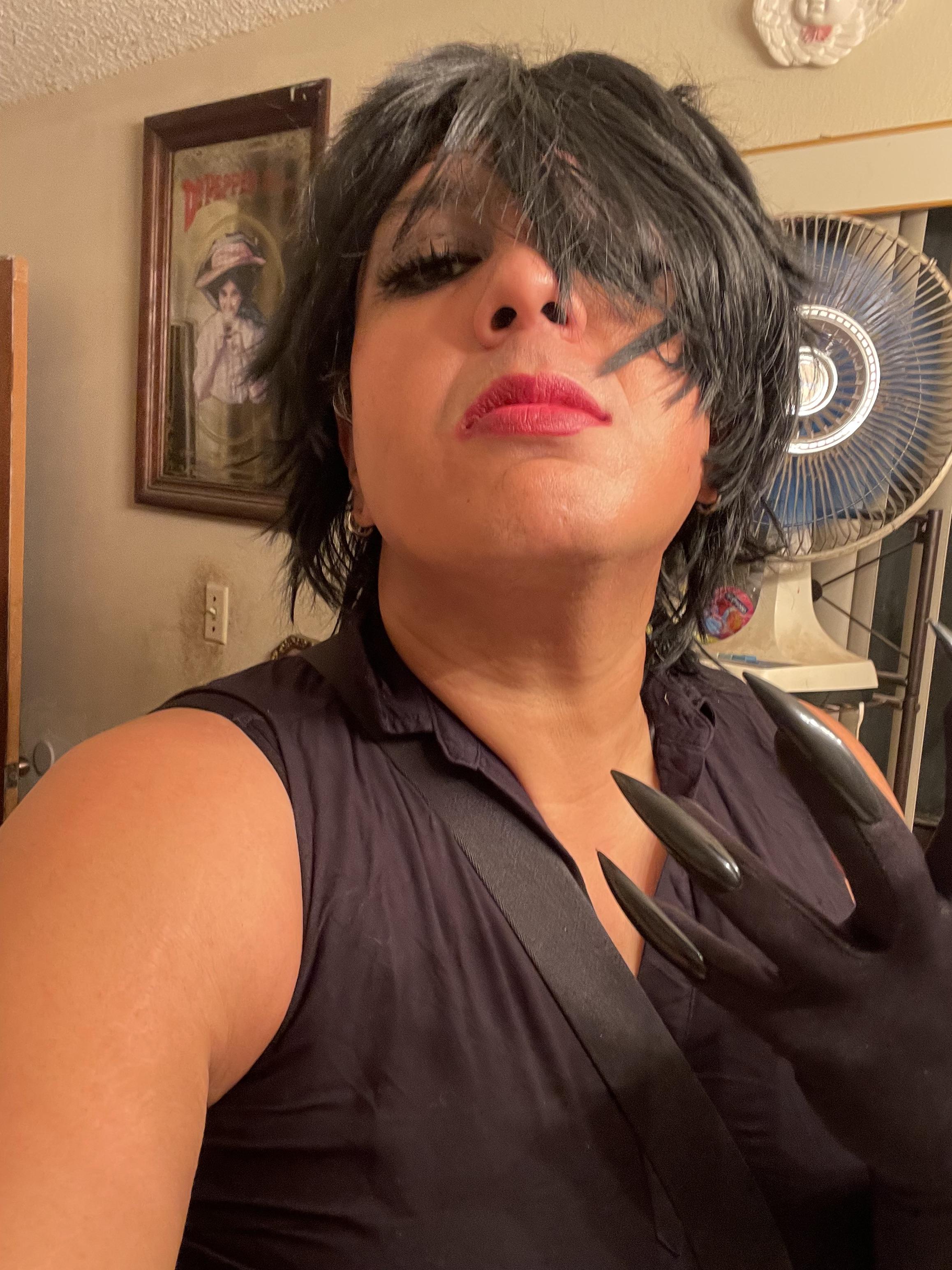 Curvy Texas sissy in a black sleeveless top, red top with black corset, and shiny black latex outfit showing a hip tattoo