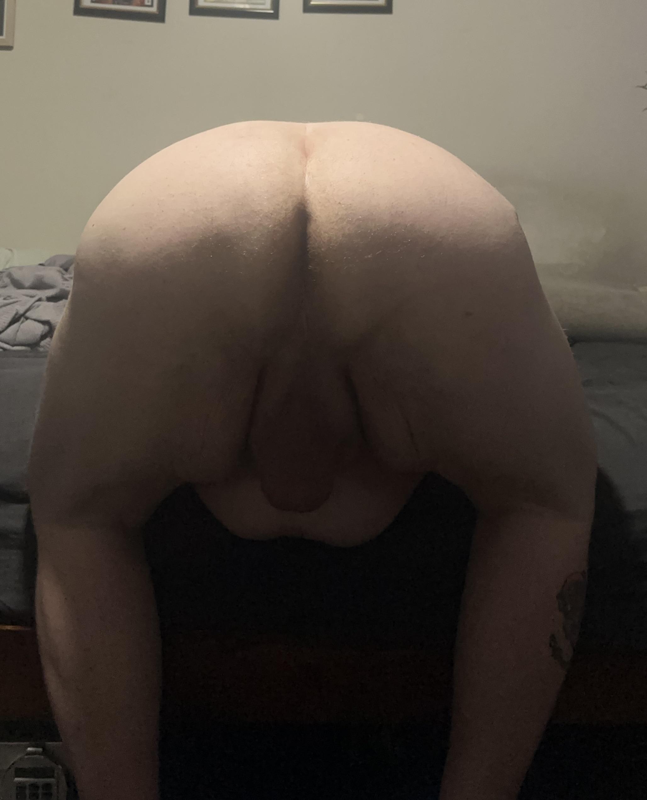 Chubby white man with a tattoo and dad bod posing for a pelfie in a bedroom