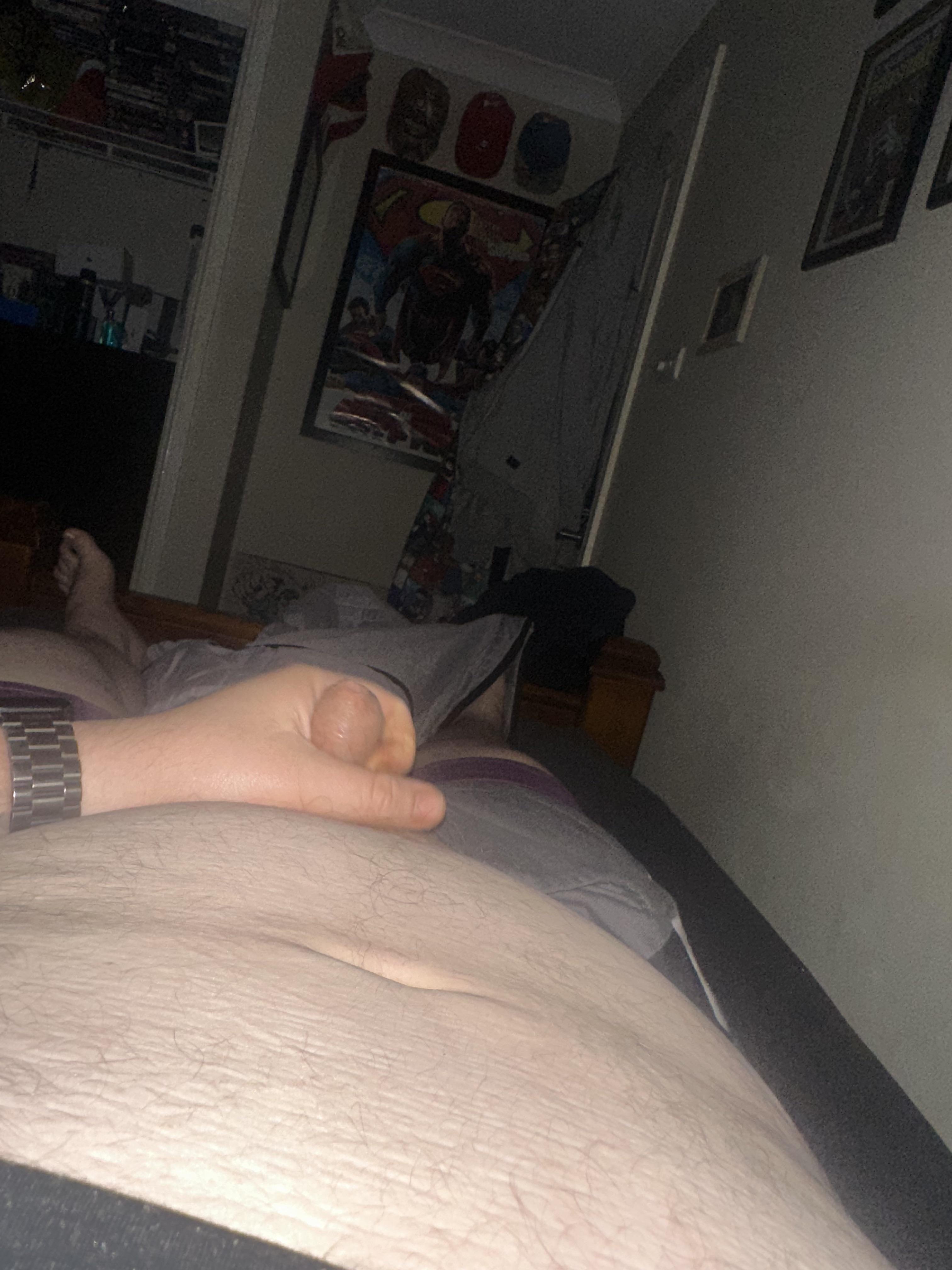 Chubby white man with a tattoo and dad bod posing for a pelfie in a bedroom