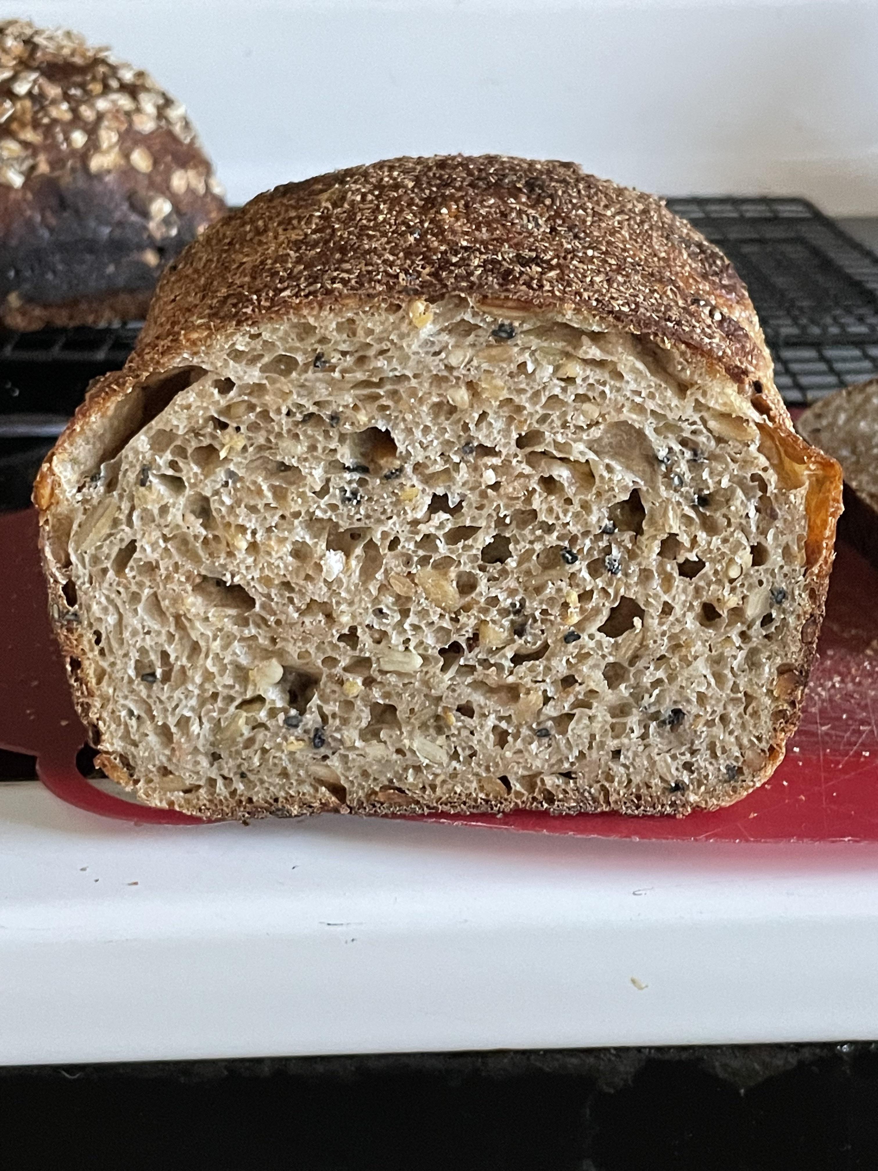 Multigrain sourdough bread from raw seeded dough to stacked baked loaves in a kitchen