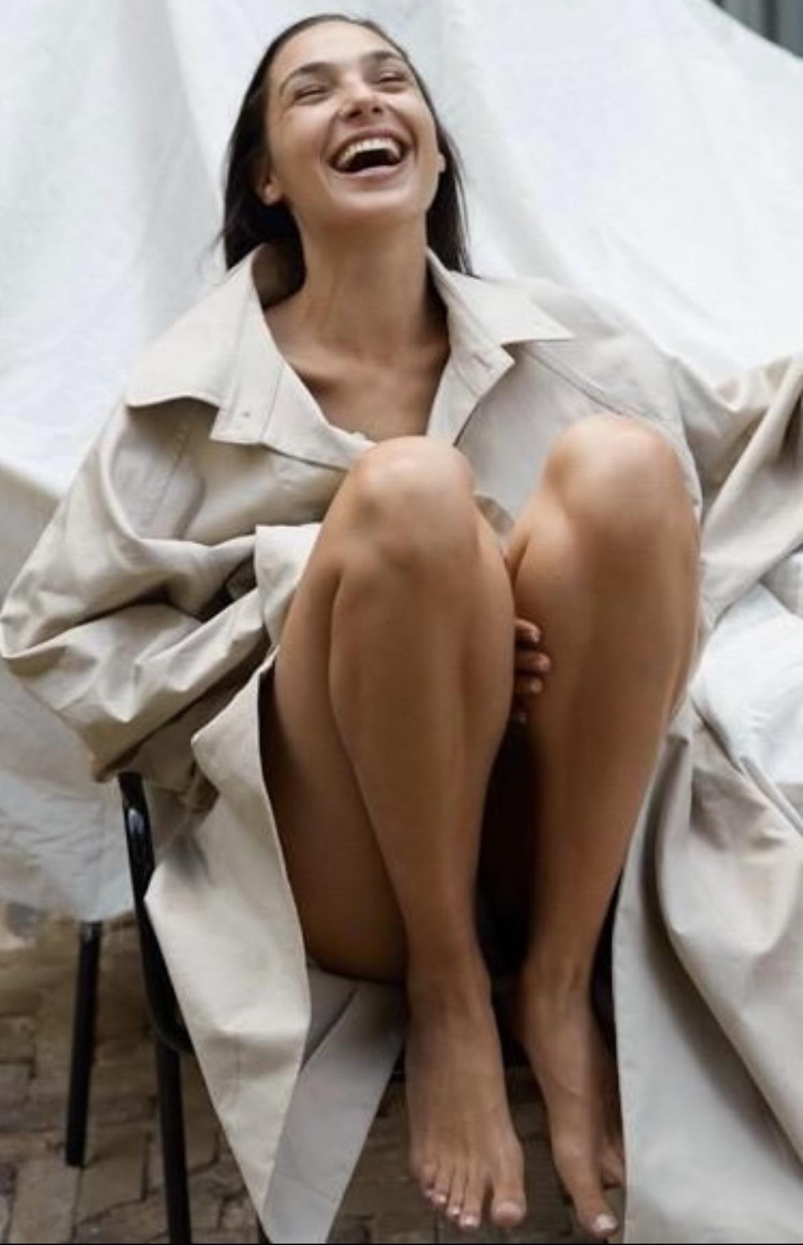 Gal Gadot and Rachel Zegler as Snow White whores, slim tanned woman in a beige oversized coat sitting with legs up