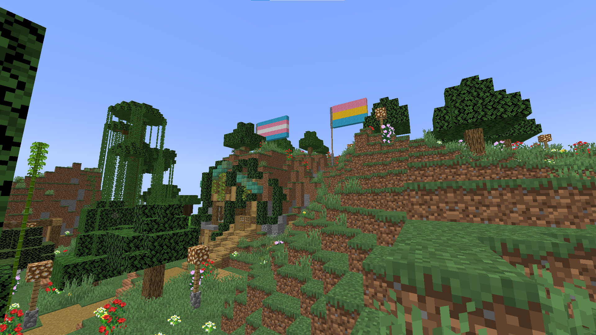 Minecraft survival builds featuring a base with flags, paths, and foliage in a beautiful landscape.