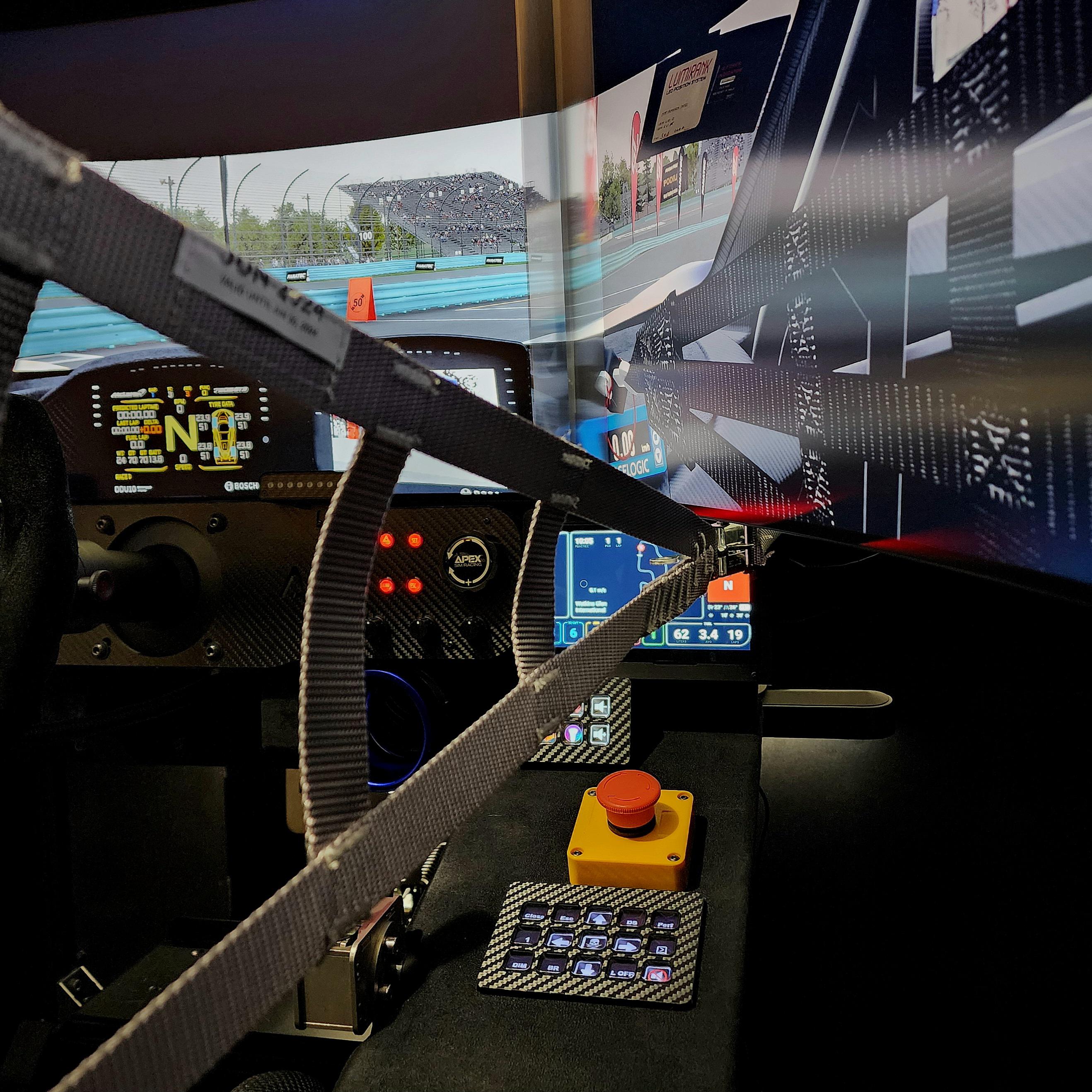 Sim racing cockpit with a professional steering wheel, digital displays, and control buttons
