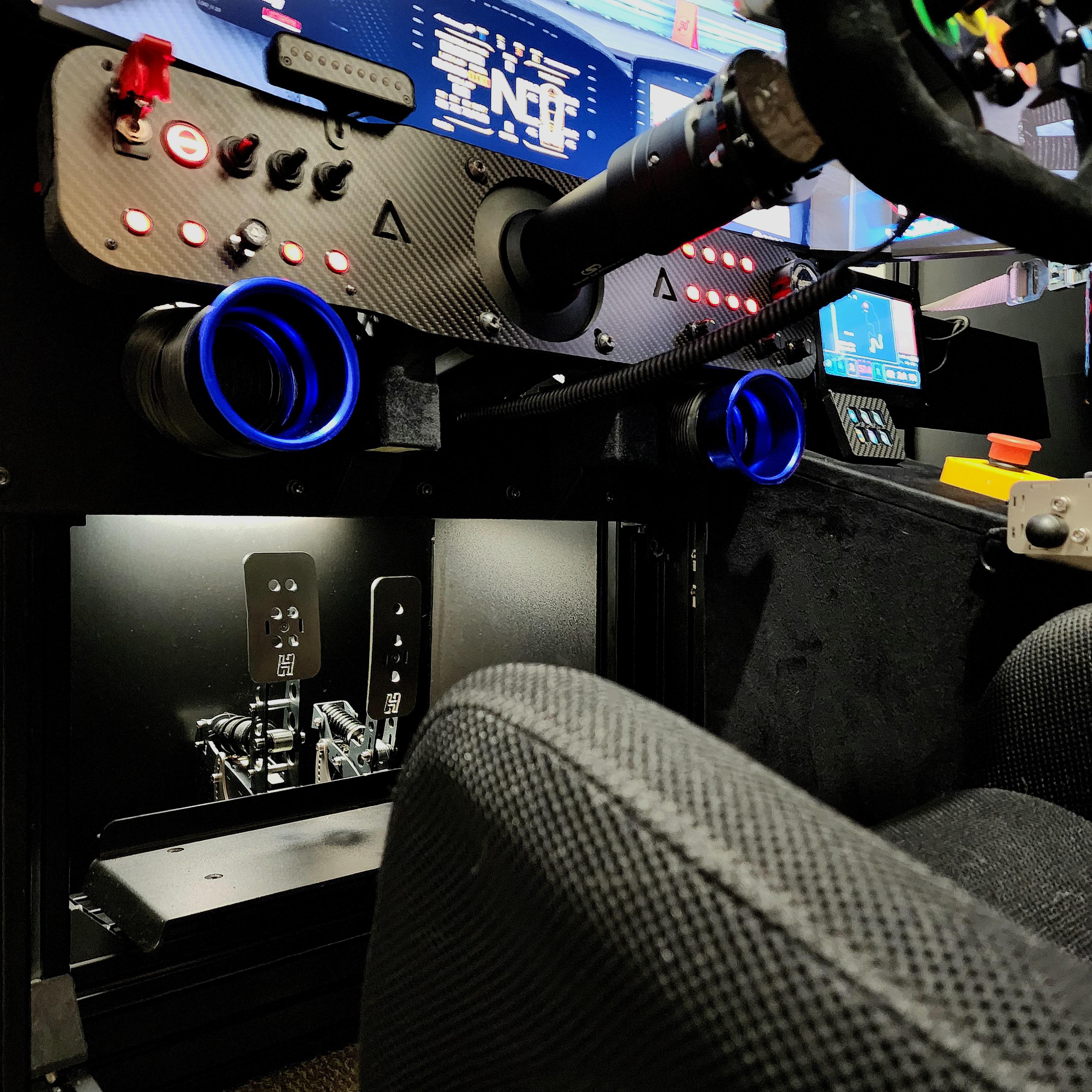 Sim racing cockpit with a professional steering wheel, digital displays, and control buttons