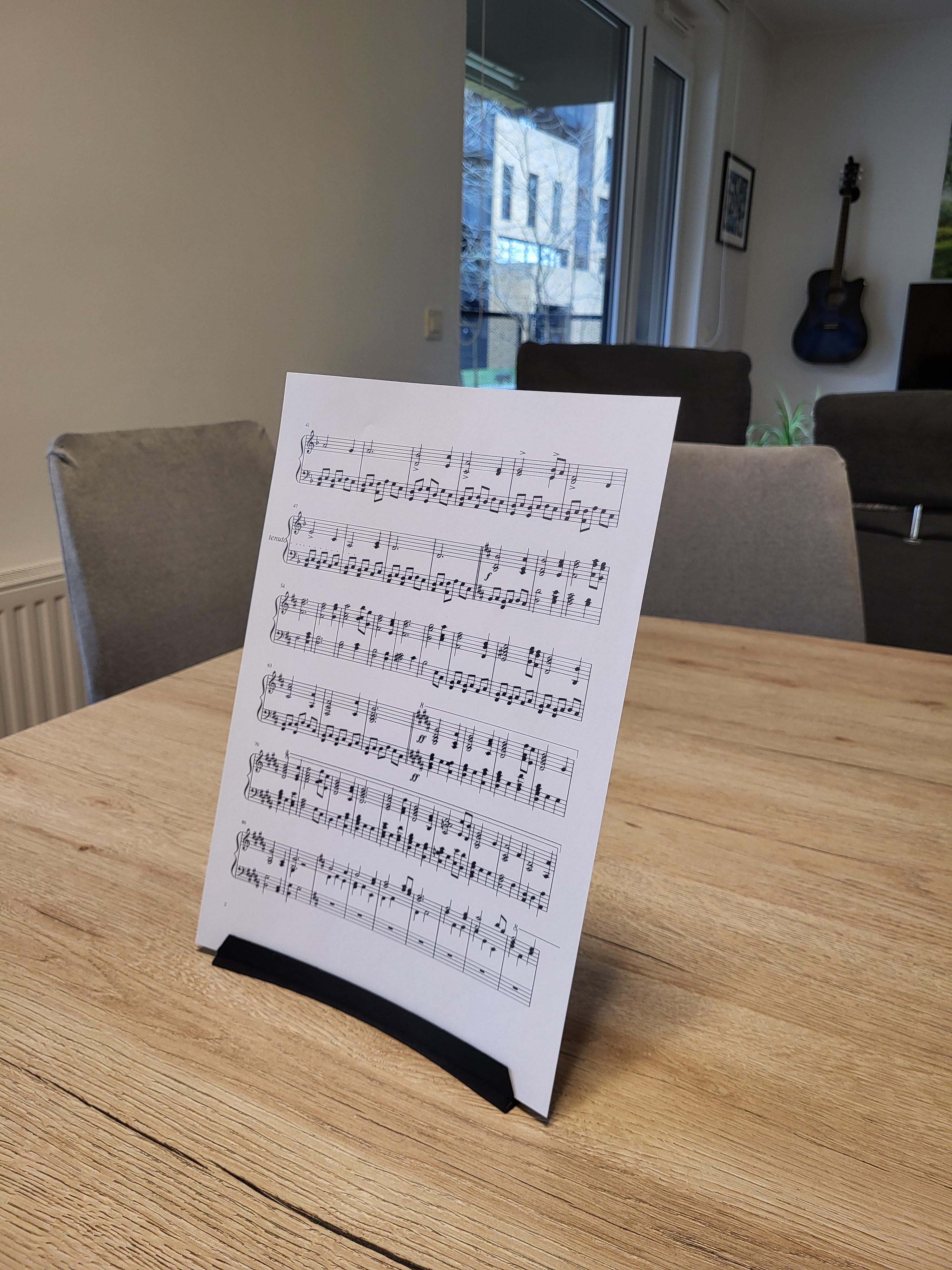 Upright paper stand holding a Dell UltraSharp 27 4K Monitor Calibration Factory Report on a wooden table