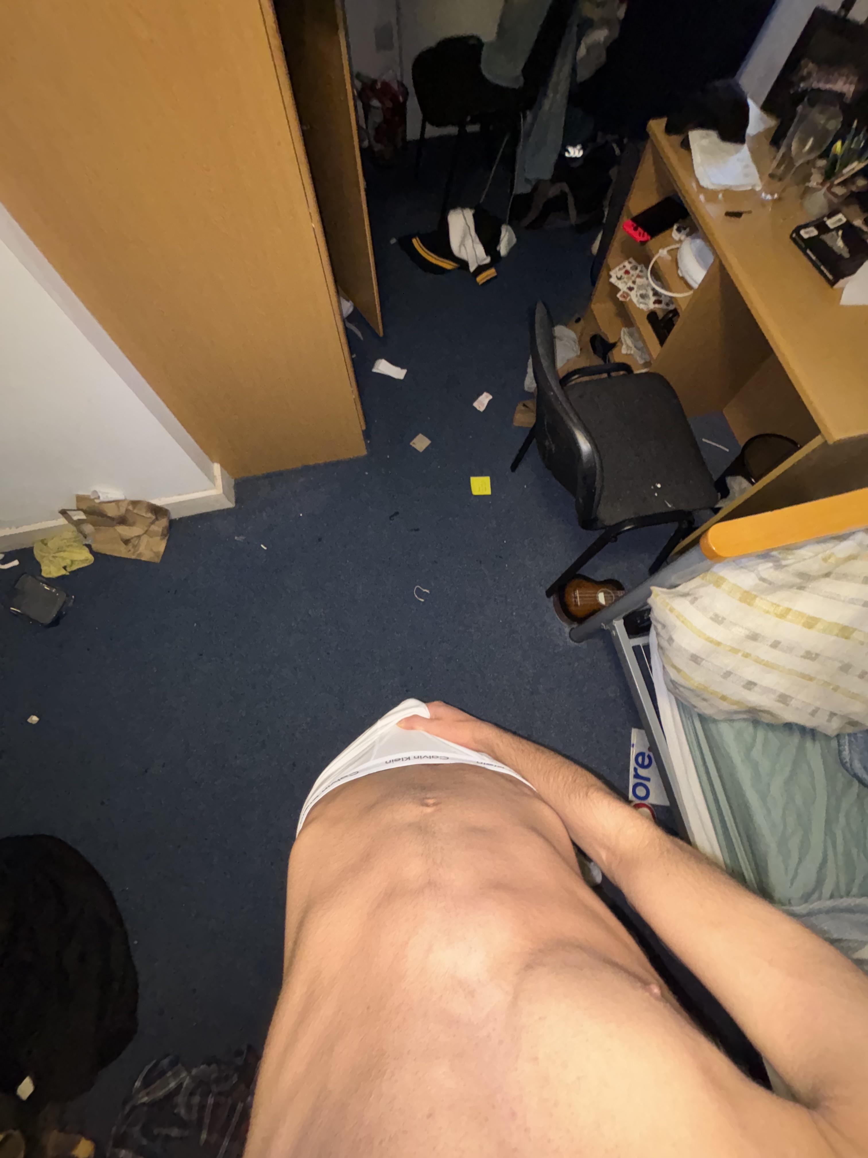 Muscular twunk college student in a bedroom posing shirtless and masturbating with an uncut penis.