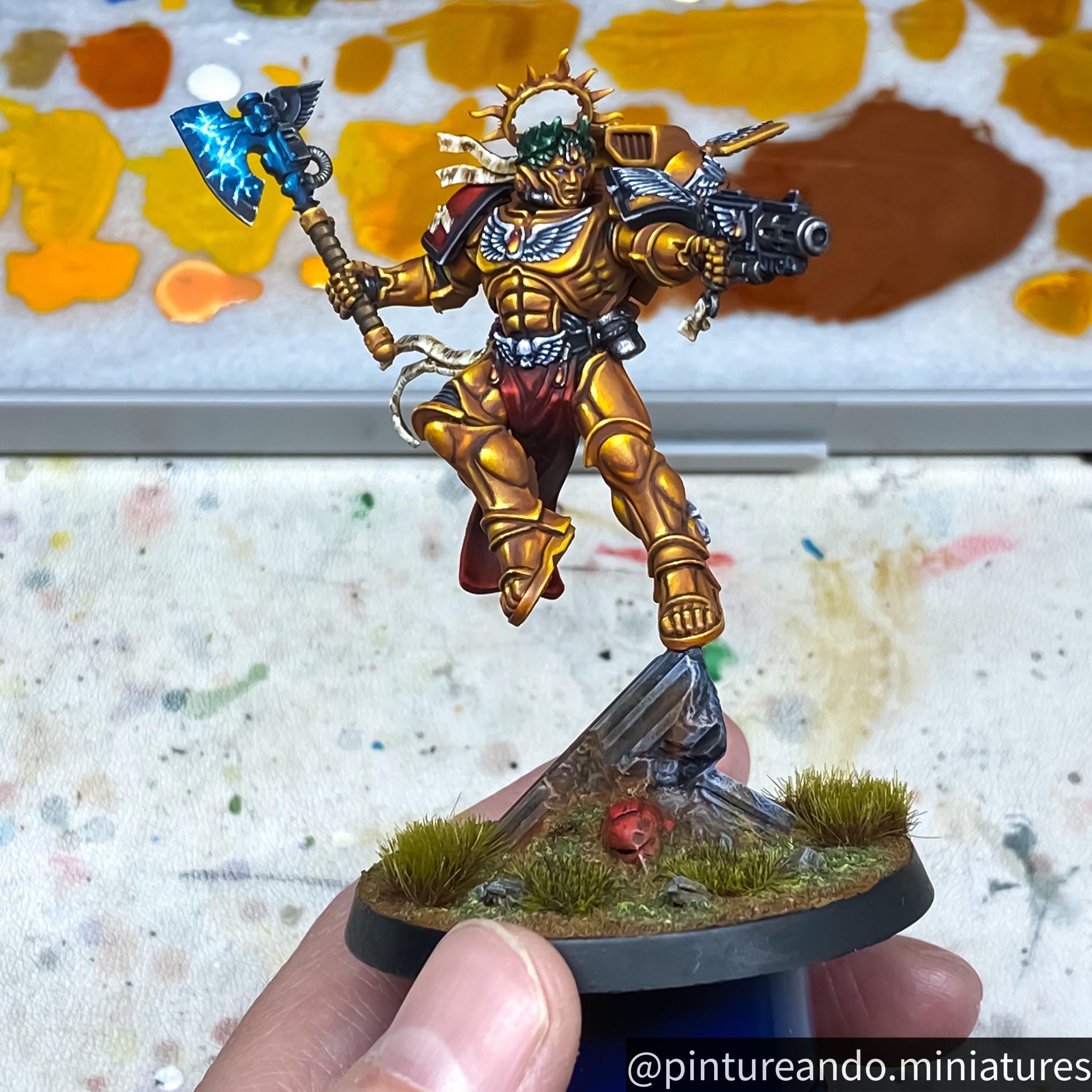 Primaris Dante miniature figure of a golden armored warrior with a blue glowing axe held by a hand