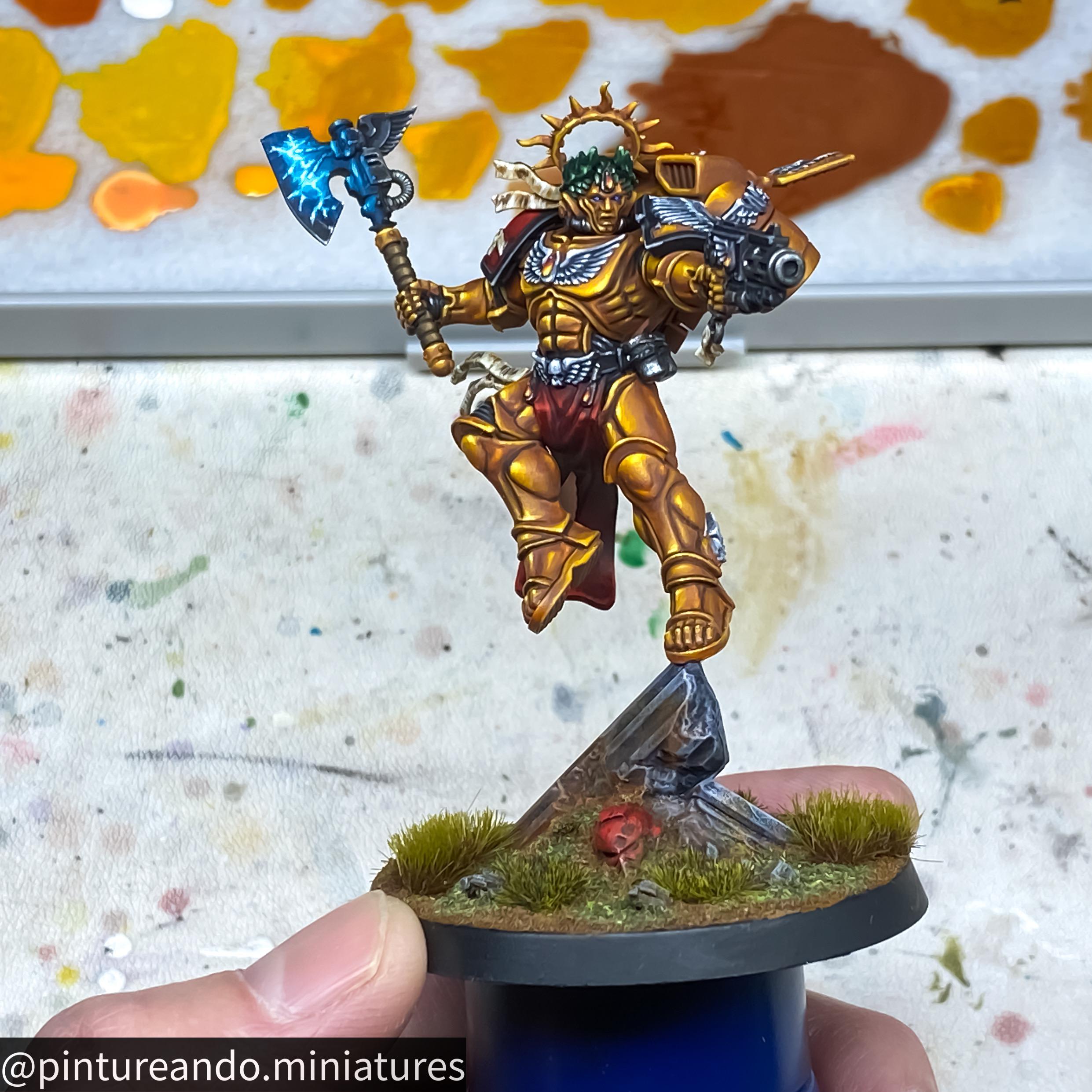 Primaris Dante miniature figure of a golden armored warrior with a blue glowing axe held by a hand