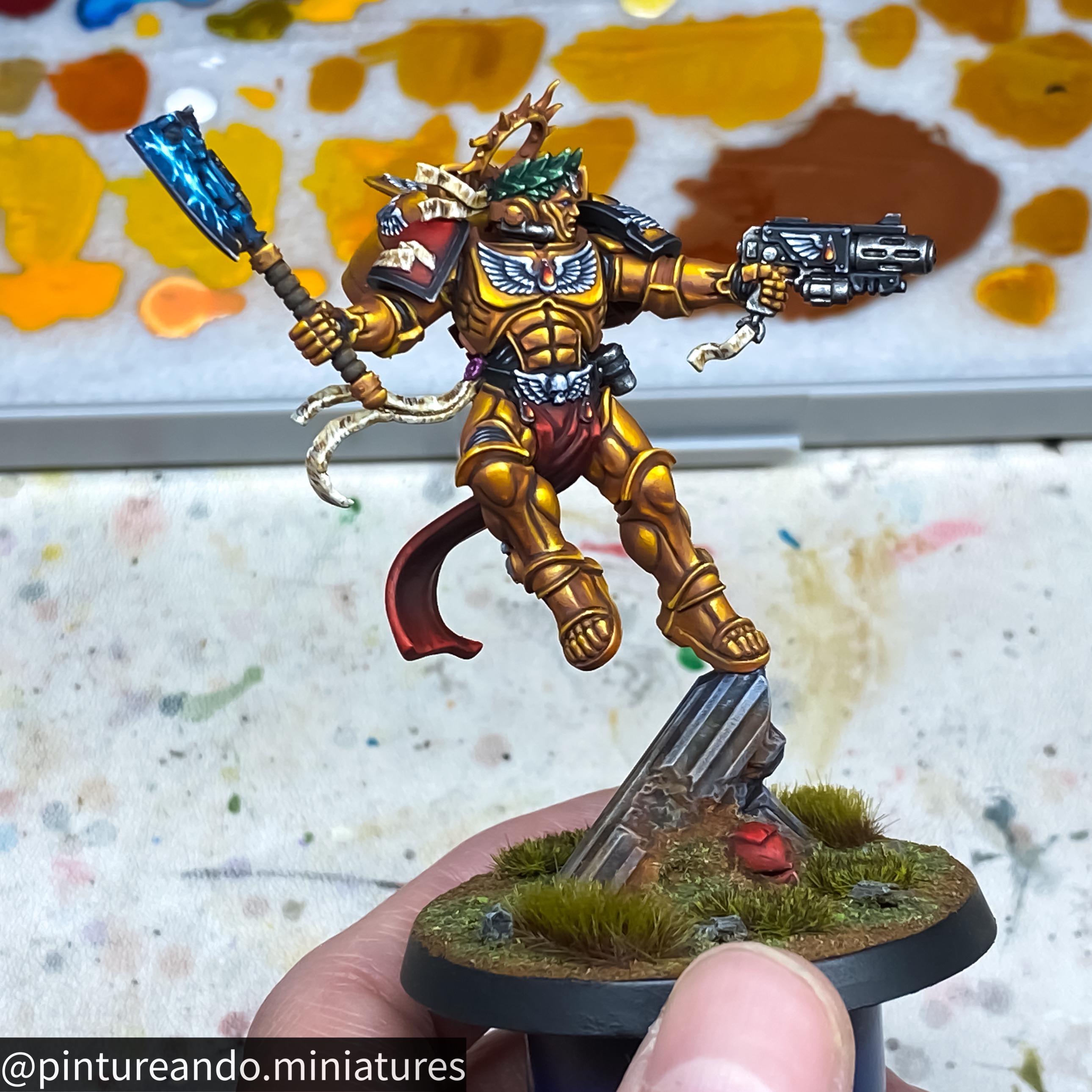 Primaris Dante miniature figure of a golden armored warrior with a blue glowing axe held by a hand