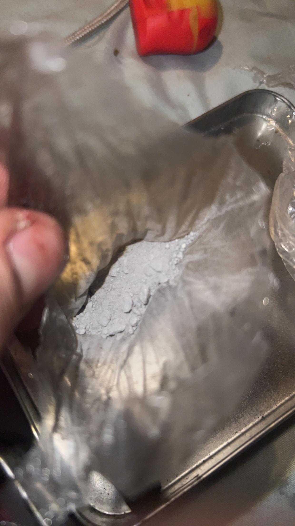 Cocaine white powder in clear plastic bags on a metallic surface