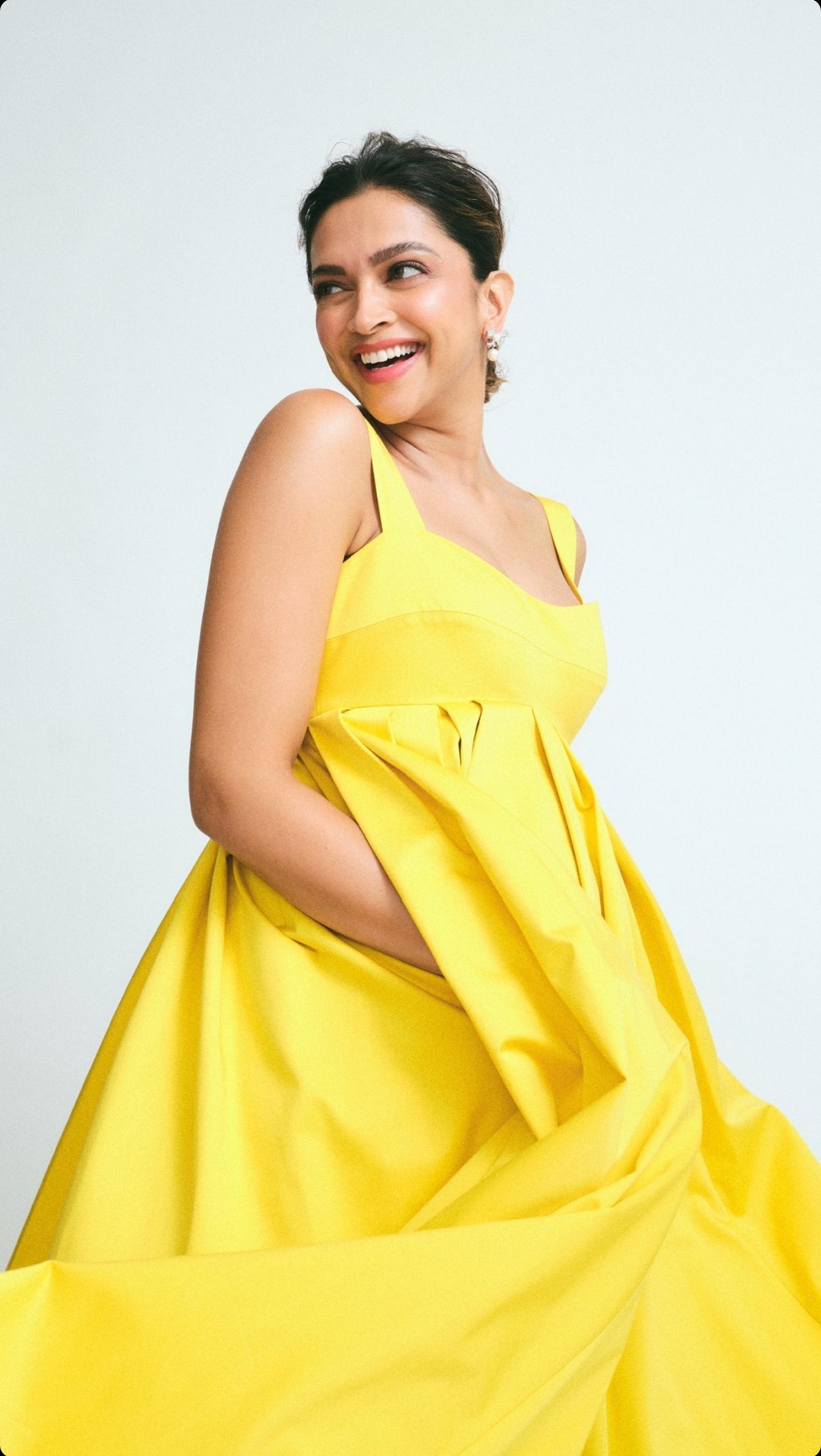 Deepika Padukone, a beautiful Indian actress and desi girl in a yellow dress, resting her chin on her hand.
