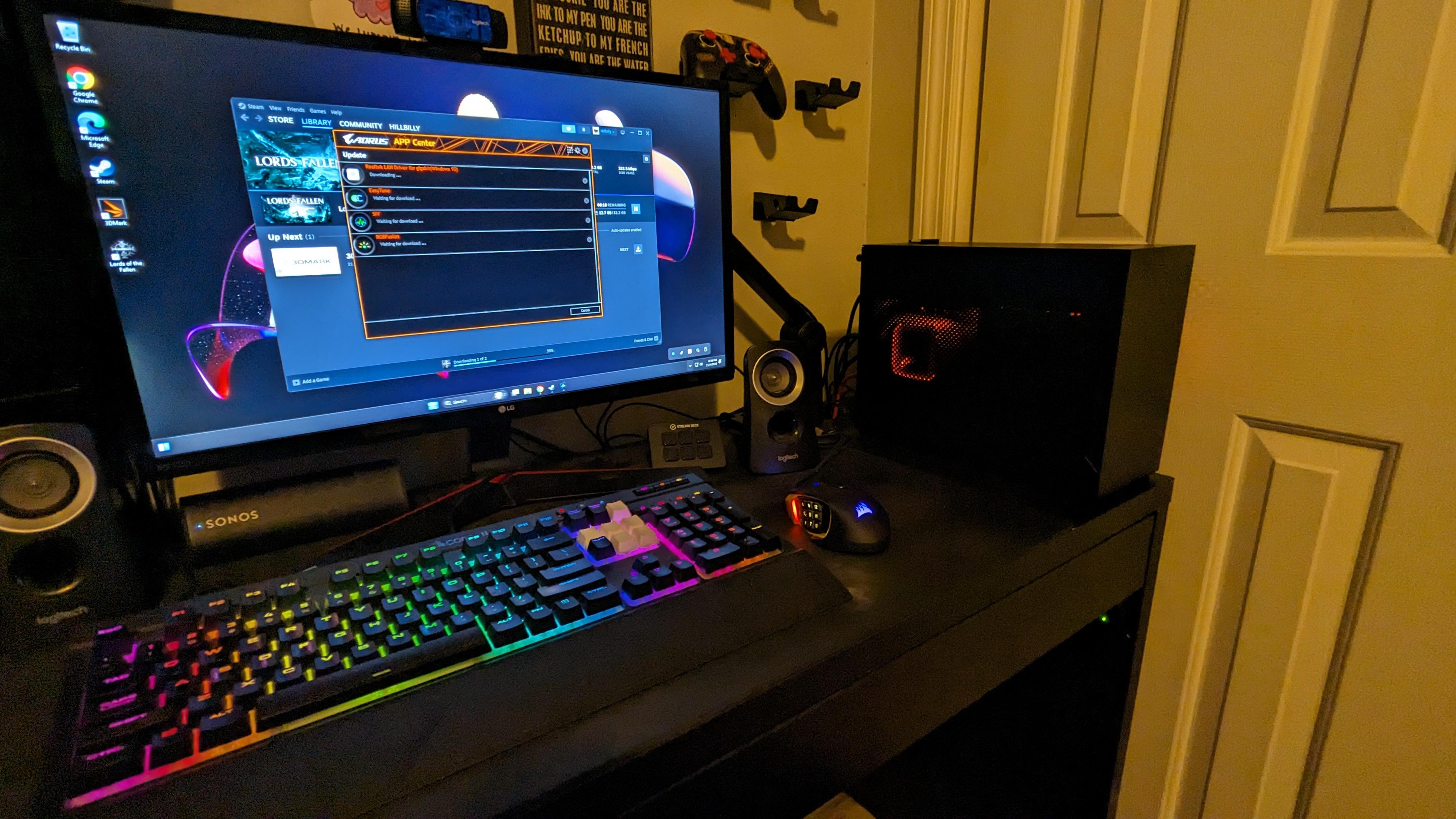 ITX gaming pc setup with a PC tower, RGB keyboard, and monitor on a black desk