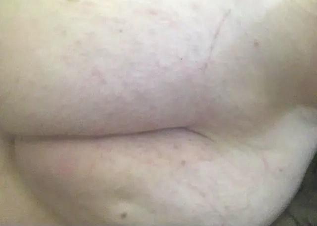 Busty white trans woman in a red shirt showing her breasts, belly, and cock