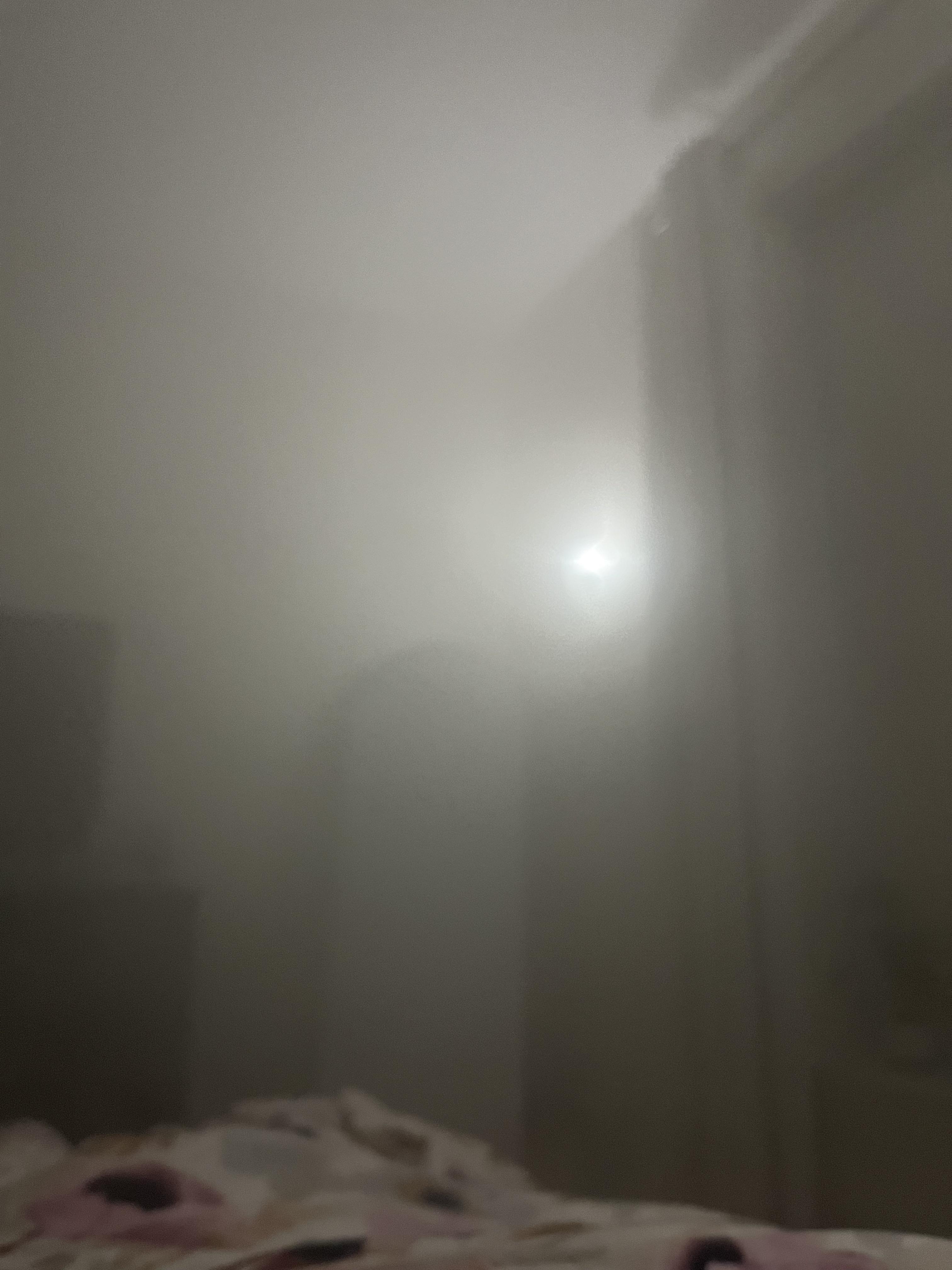 Cursed AI image of a foggy indoor room with floral print bed sheets and a dark rectangular object.