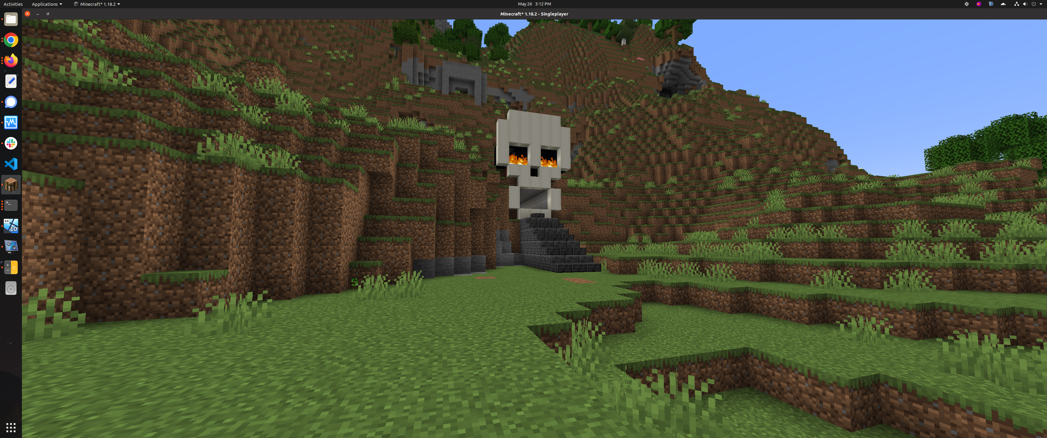 A large skull structure built into a grassy hill as an entrance to a Minecraft skeleton spawner farm