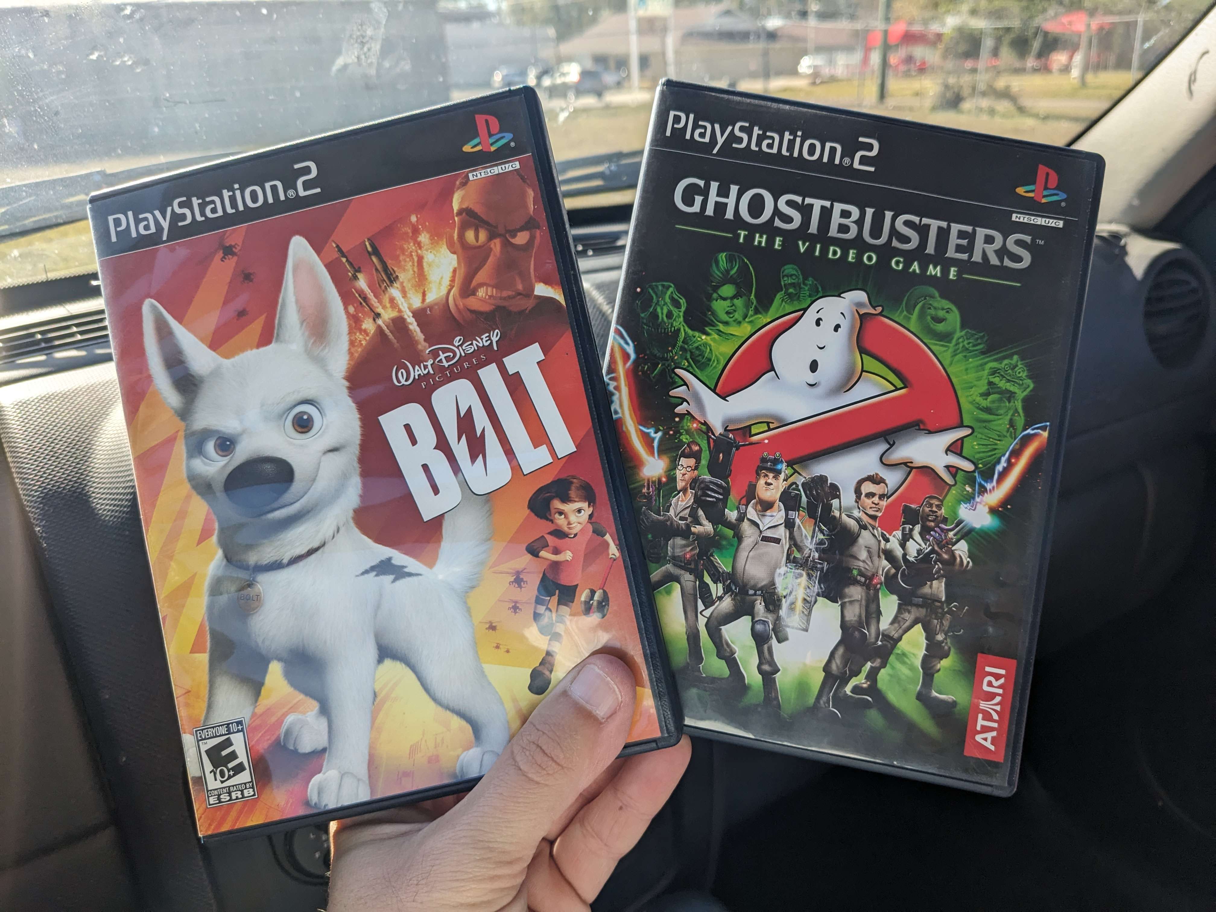 Ghostbusters: The Video Game cases for Wii, PlayStation 2, Xbox 360, and PS4 on a wooden table