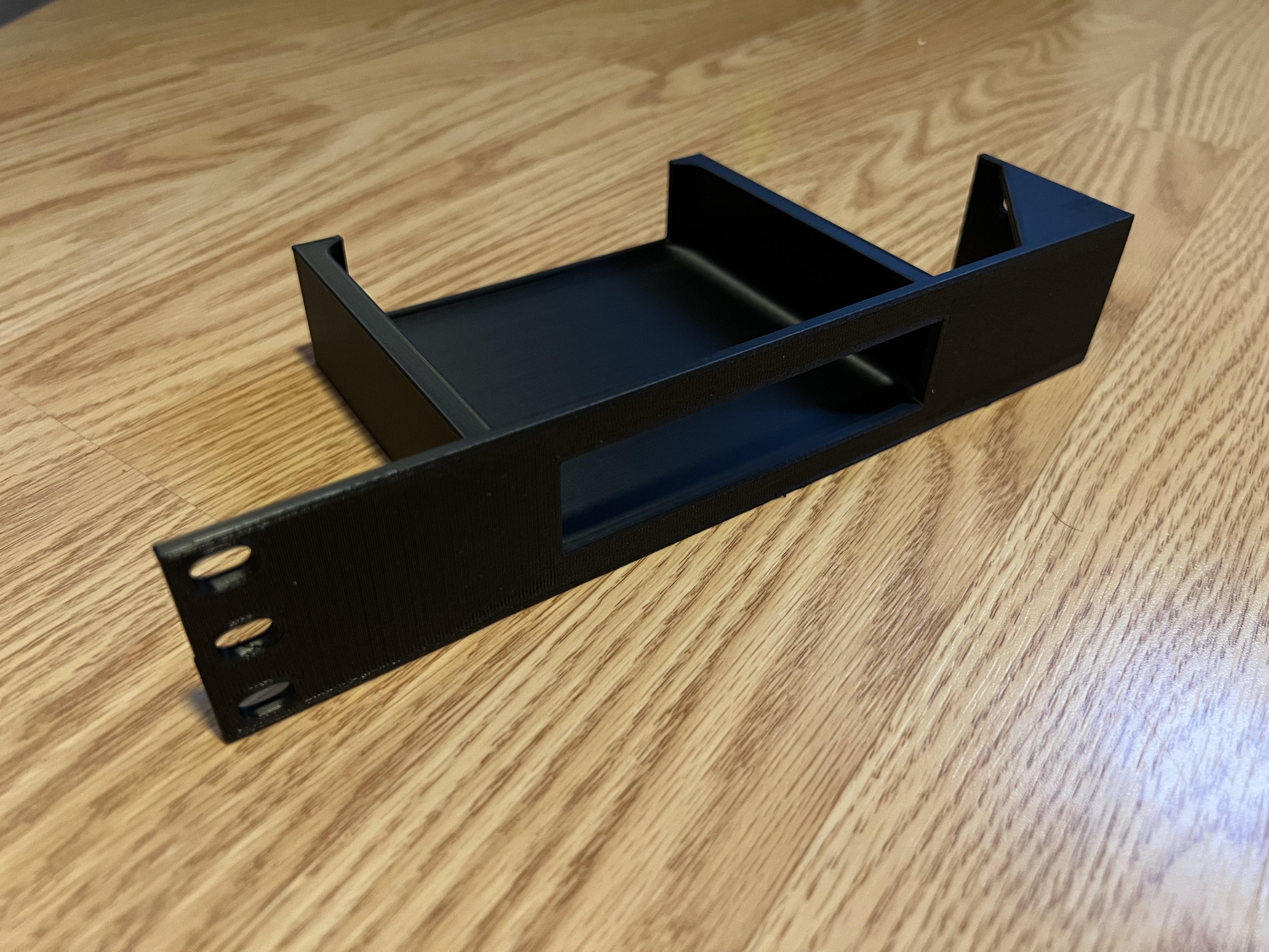 Custom modular server rack mount 3D-printed in black plastic on a wooden surface.