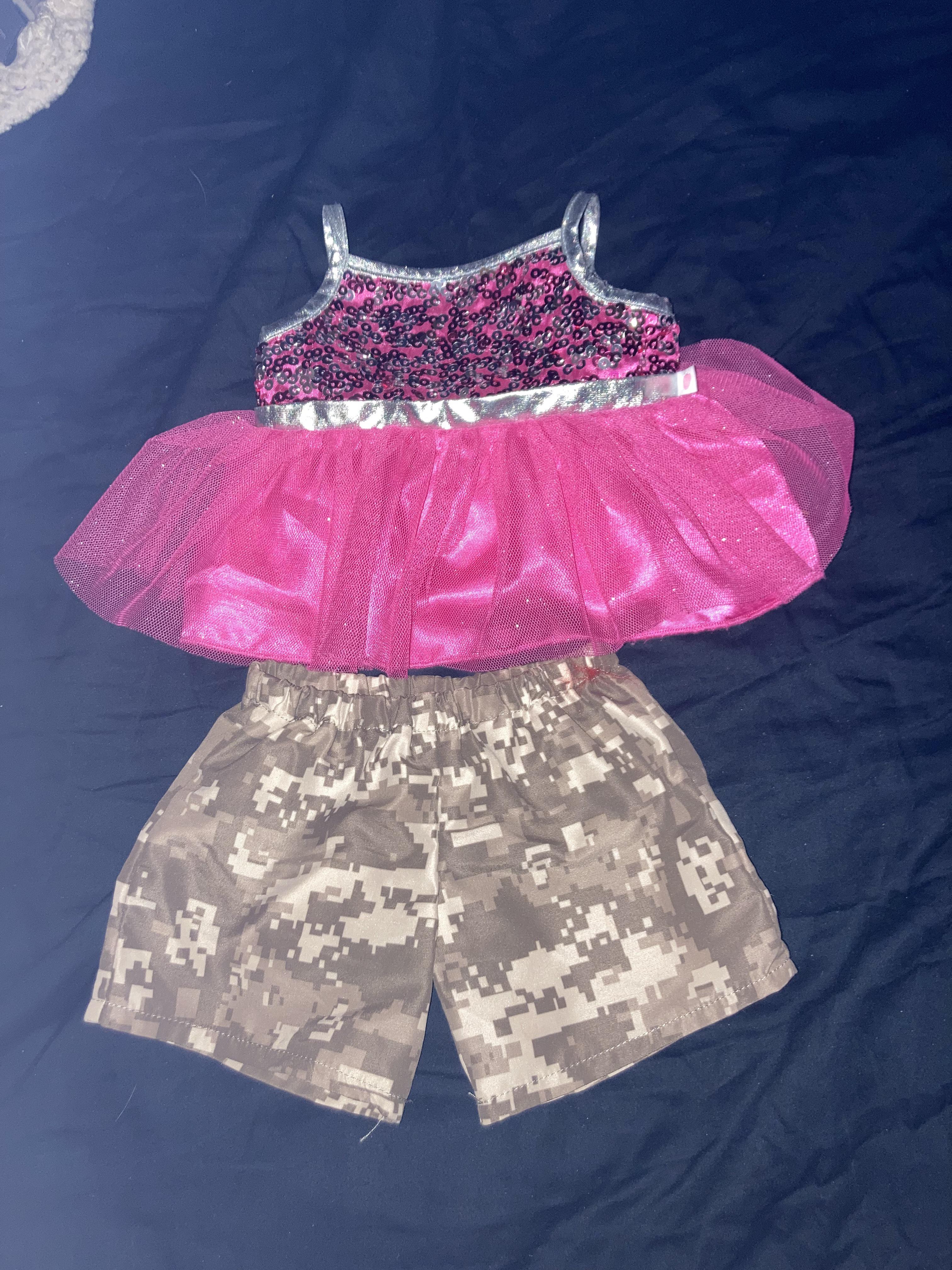 Thrift haul featuring a Hello Kitty tank top, sunflower white shirt, pink tutu top, and a striped turtleneck