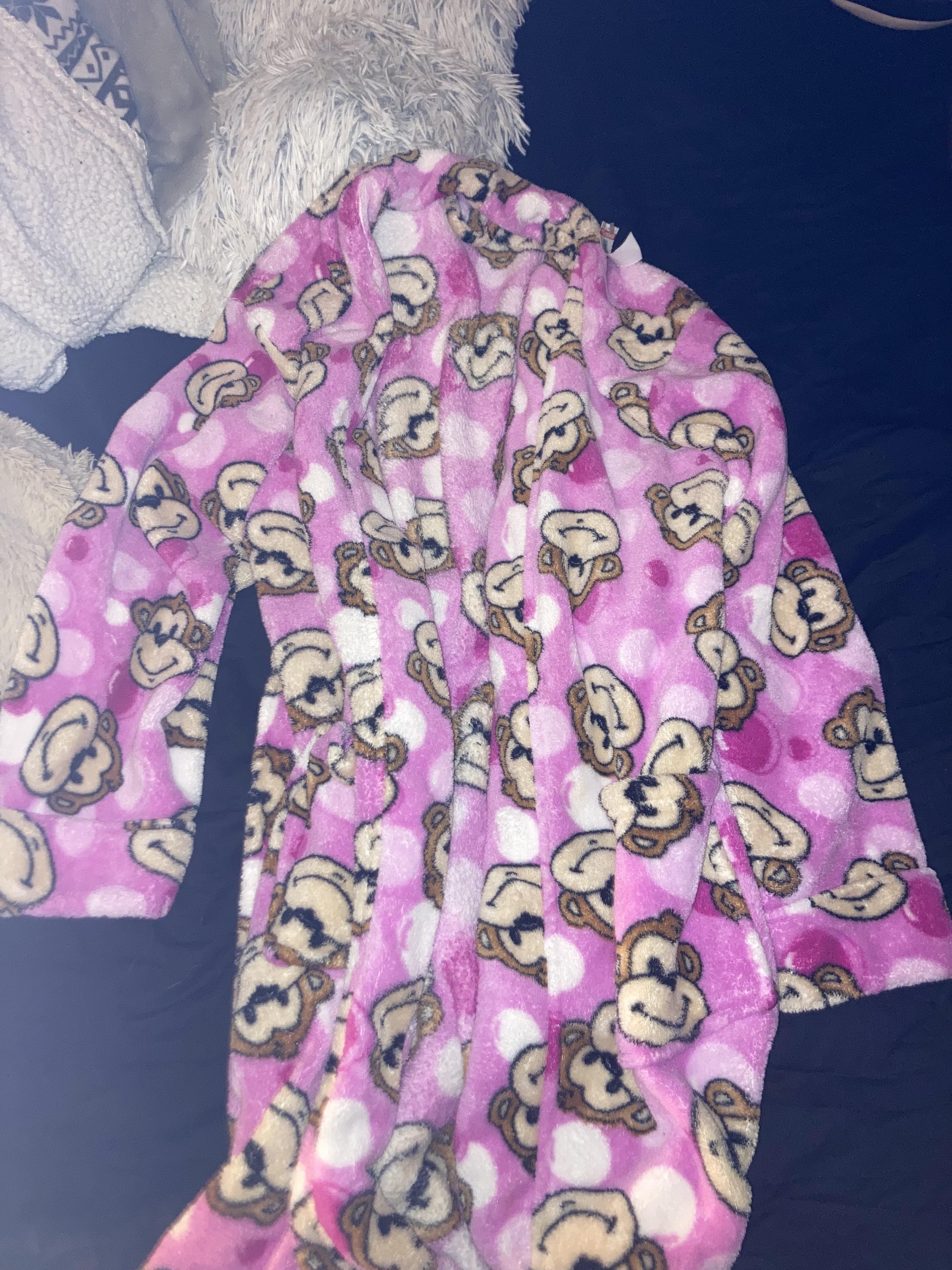 Thrift haul featuring a Hello Kitty tank top, sunflower white shirt, pink tutu top, and a striped turtleneck
