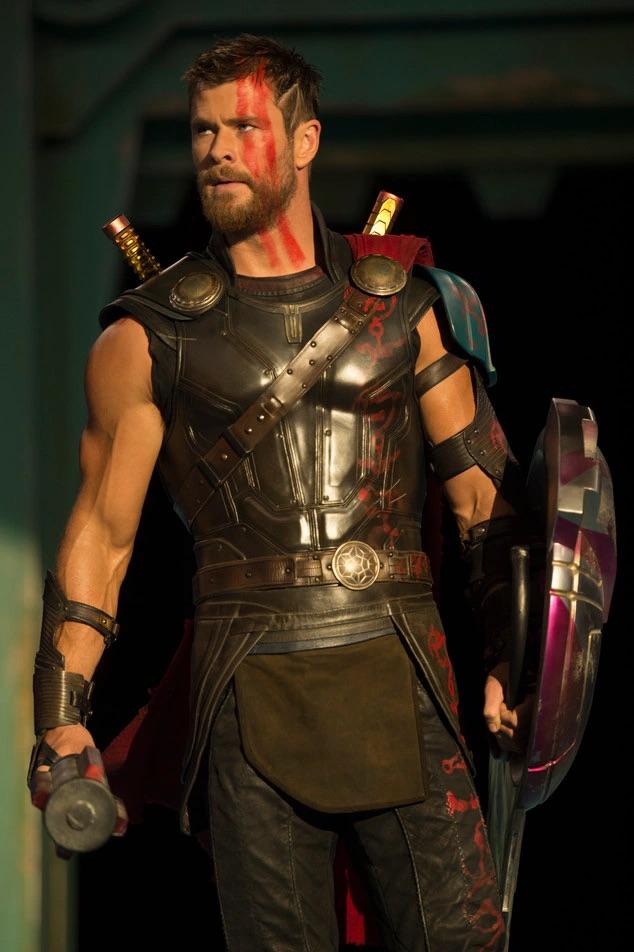 Muscular man in dark armor with a red cape and a slender woman with long blonde hair and a dark crown
