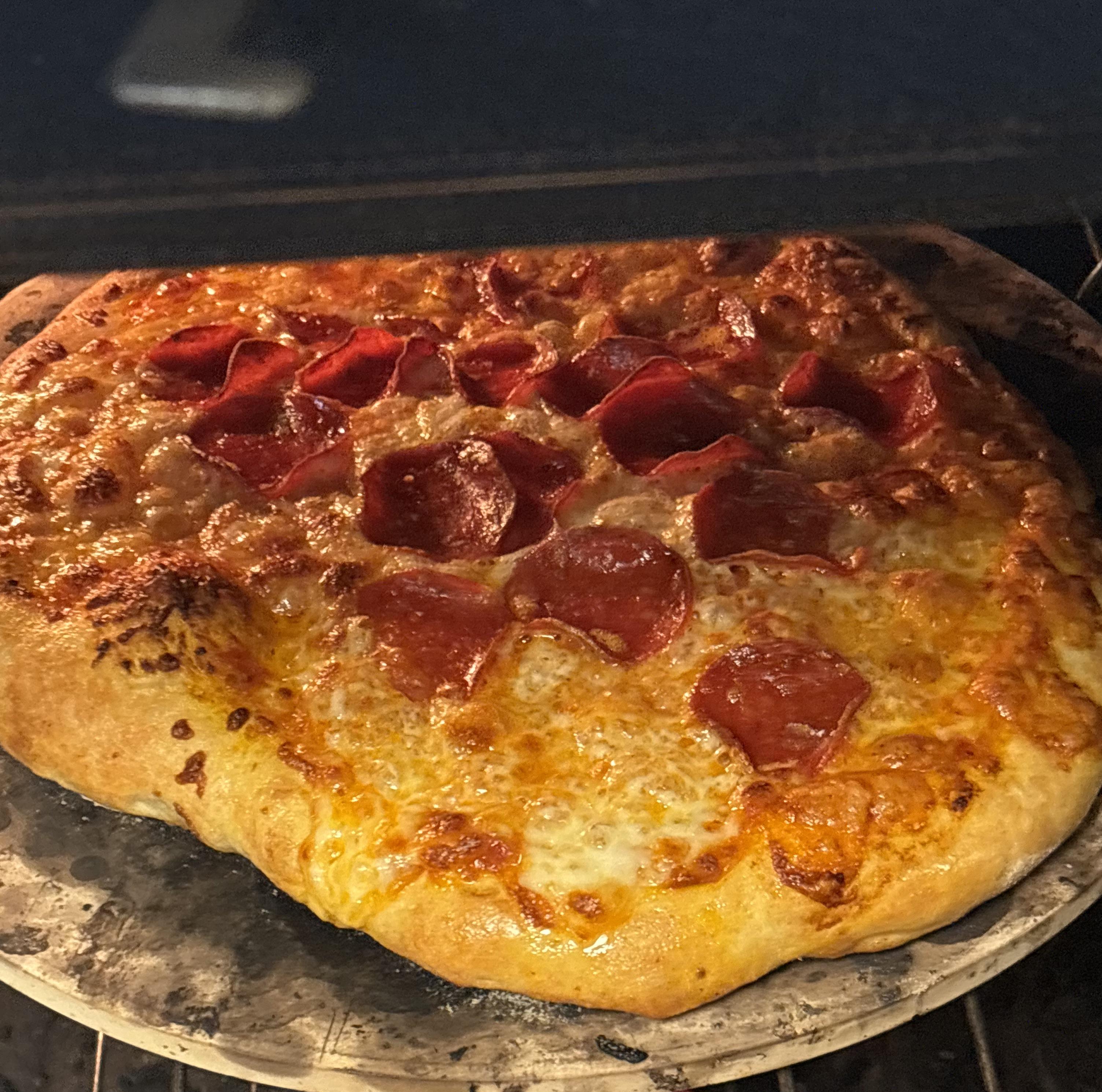 Turkey pepperoni pizza and a thick loaf of bread in an indoor kitchen