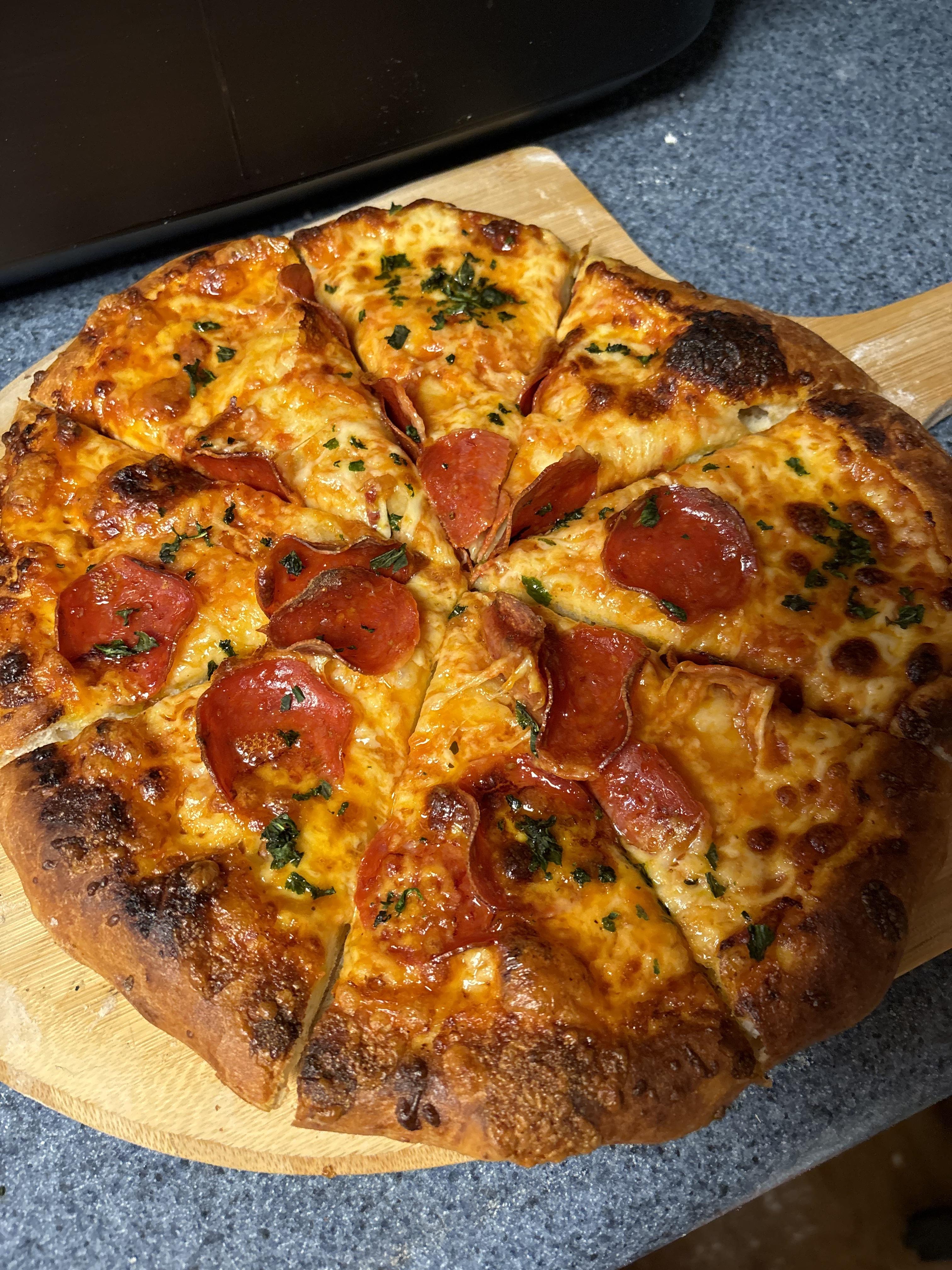 Turkey pepperoni pizza and a thick loaf of bread in an indoor kitchen