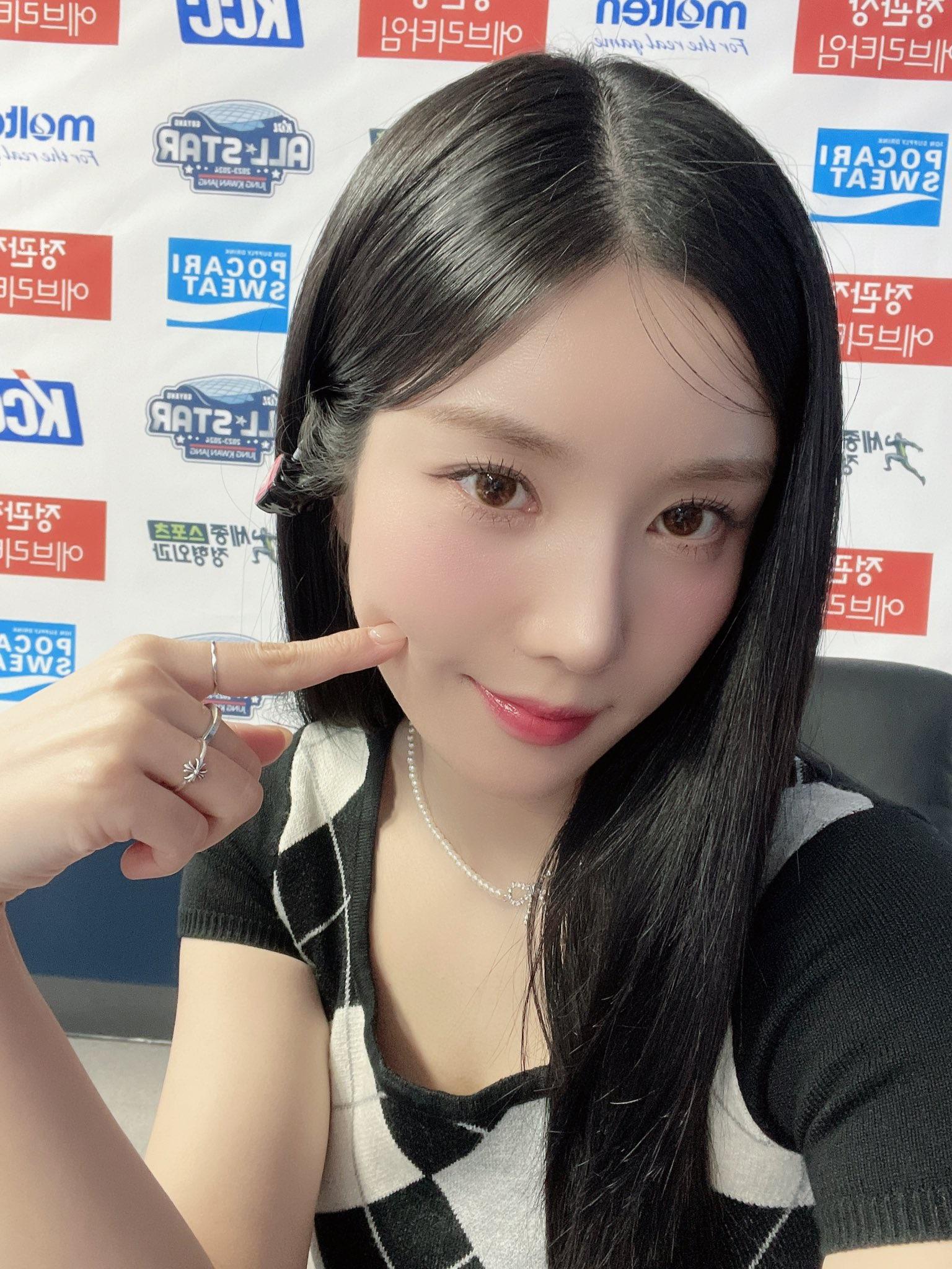 Kwon Eunbi taking a selfie with a peace sign, wearing a checkered sleeveless top and red lipstick