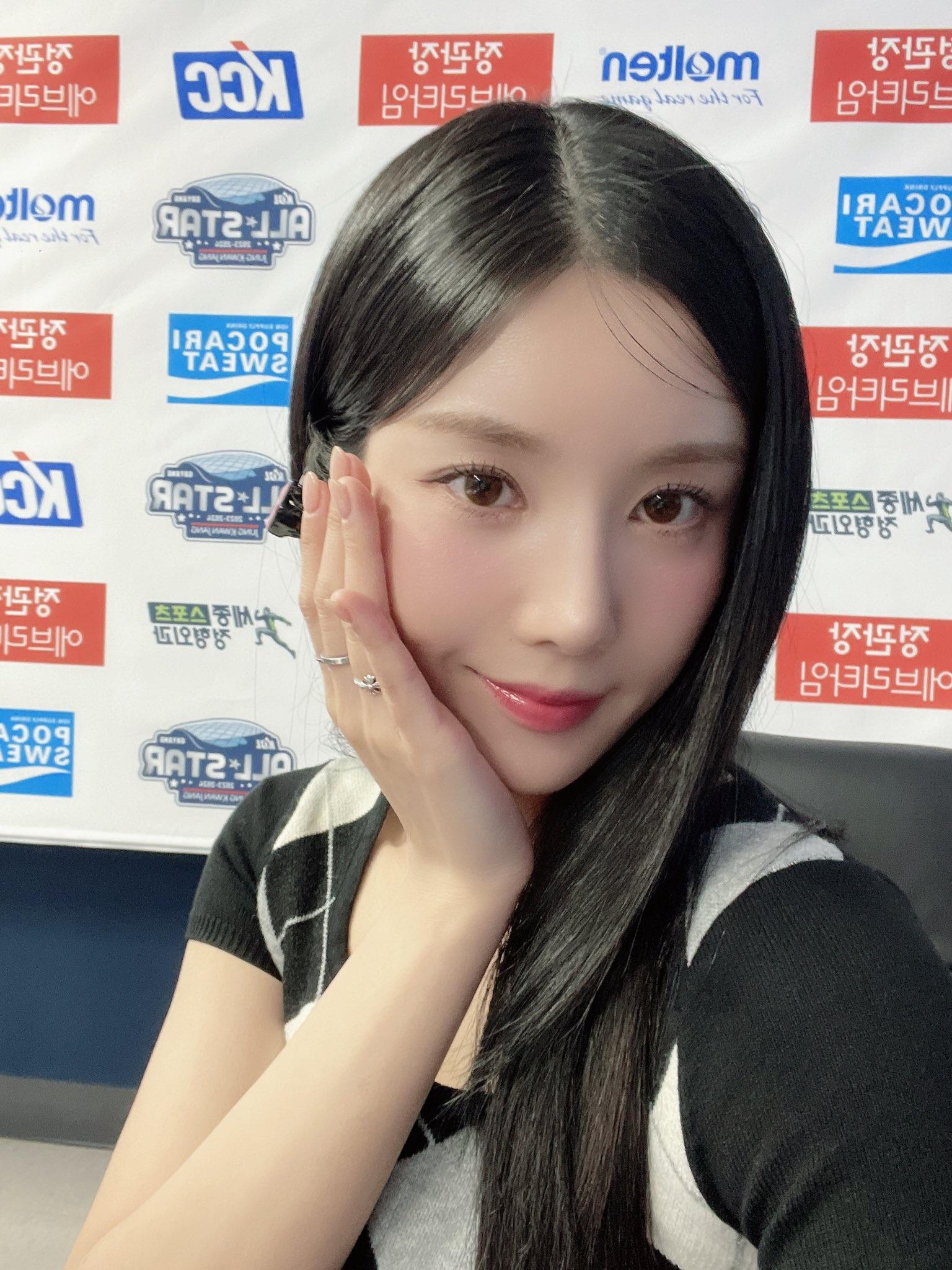 Kwon Eunbi taking a selfie with a peace sign, wearing a checkered sleeveless top and red lipstick