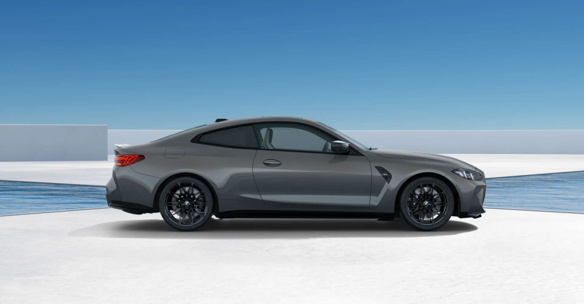Grey BMW M8 coupe in a minimalist white architectural space by the ocean