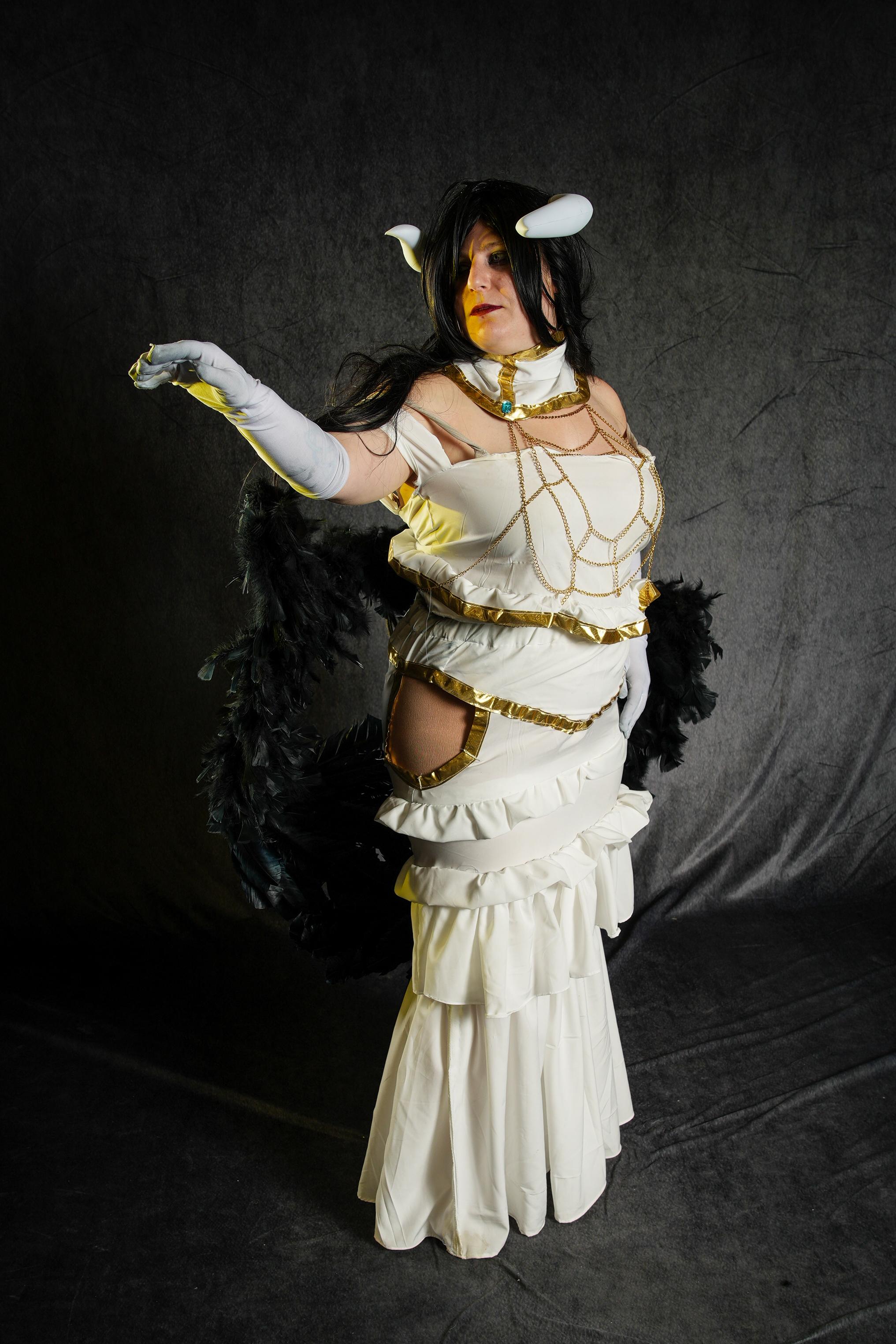 Albedo from Overlord in a white and gold strapless dress with black wings and horns