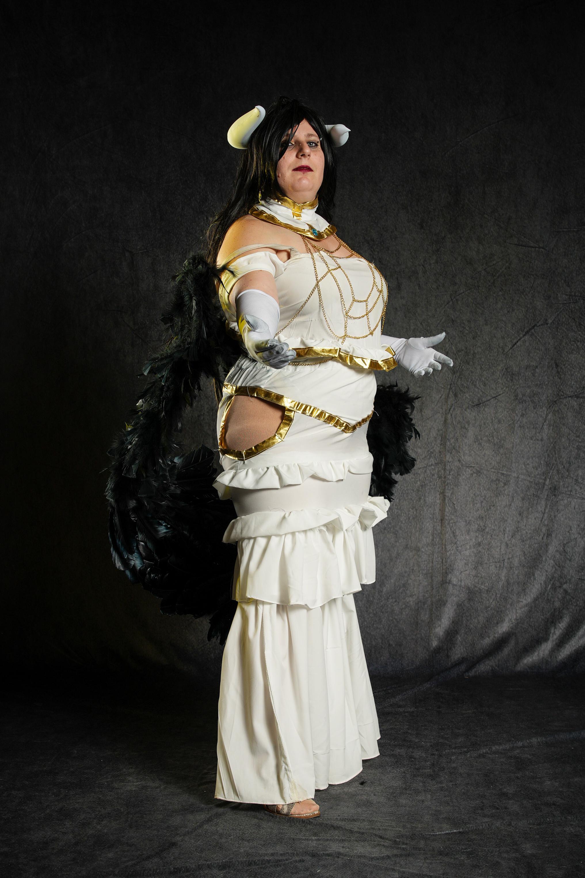 Albedo from Overlord in a white and gold strapless dress with black wings and horns