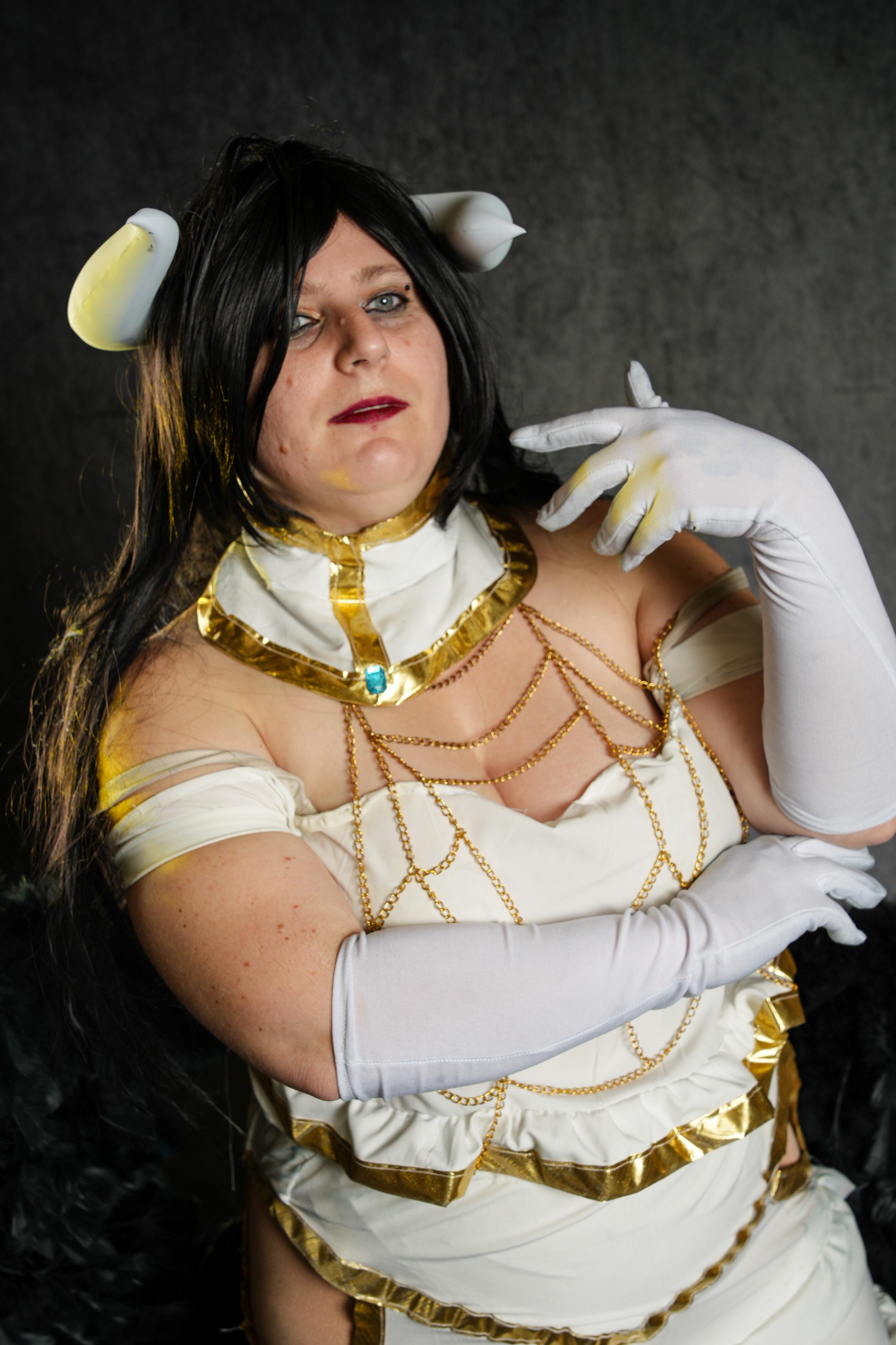 Albedo from Overlord in a white and gold strapless dress with black wings and horns