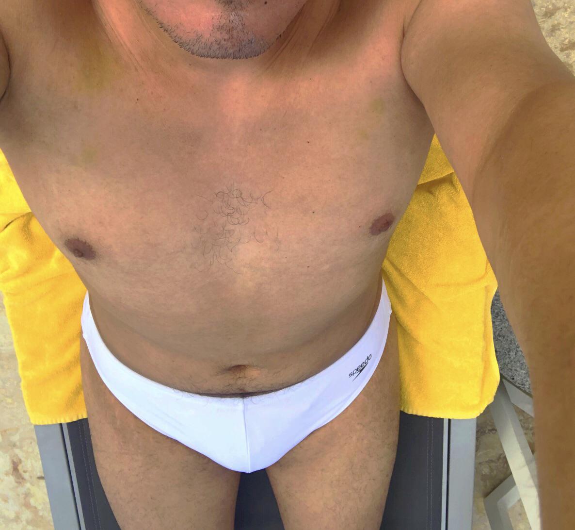 Thicc mature man with a dad bod posing in white briefs at a pool and beach